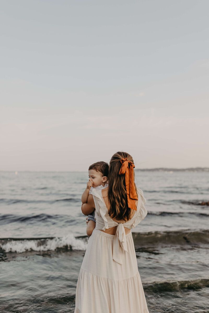 Serene beachside portrait session with gentle waves and overcast sky.