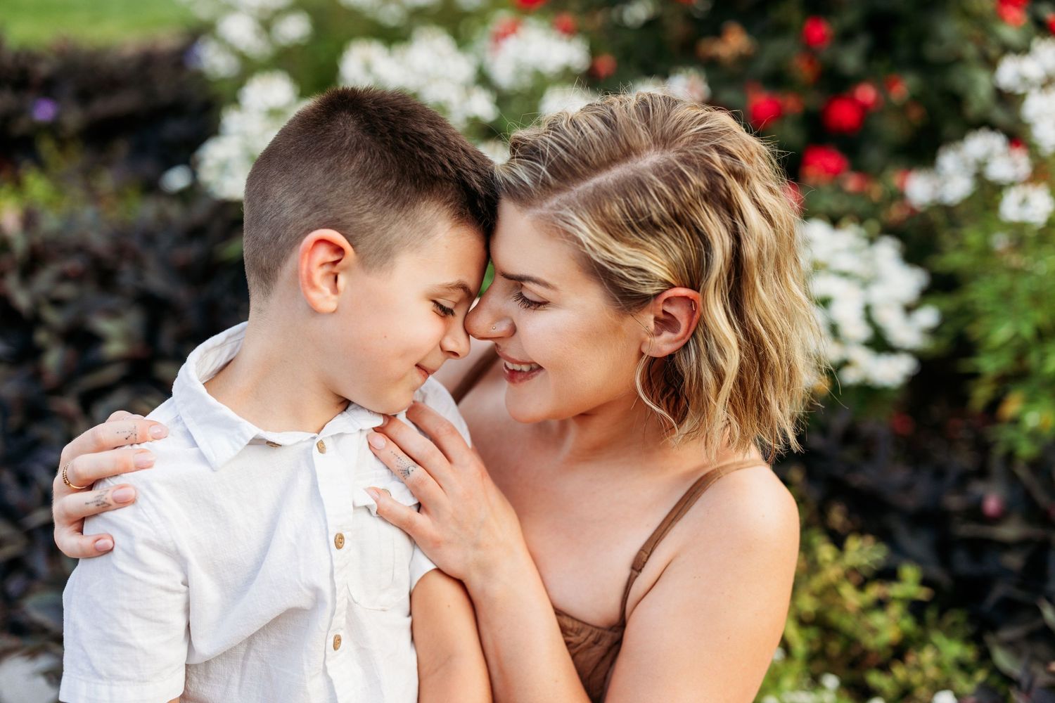 Intimate family portrait moments captured in a rose garden setting.