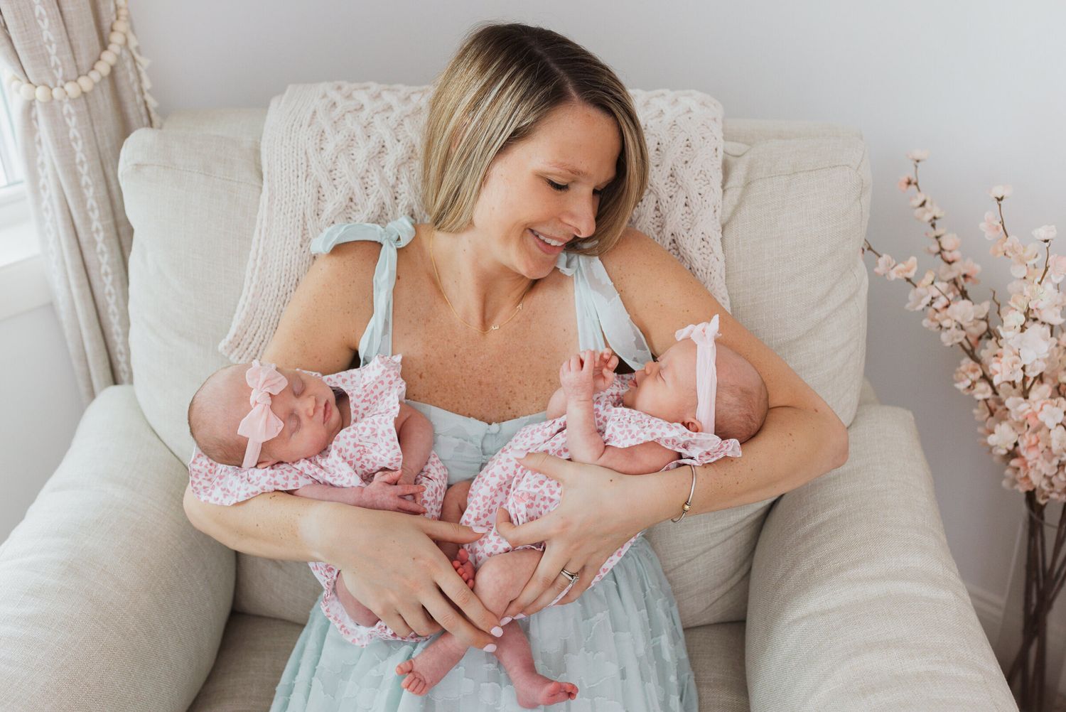 Tender moments shared on white couch with baby in pink dress.