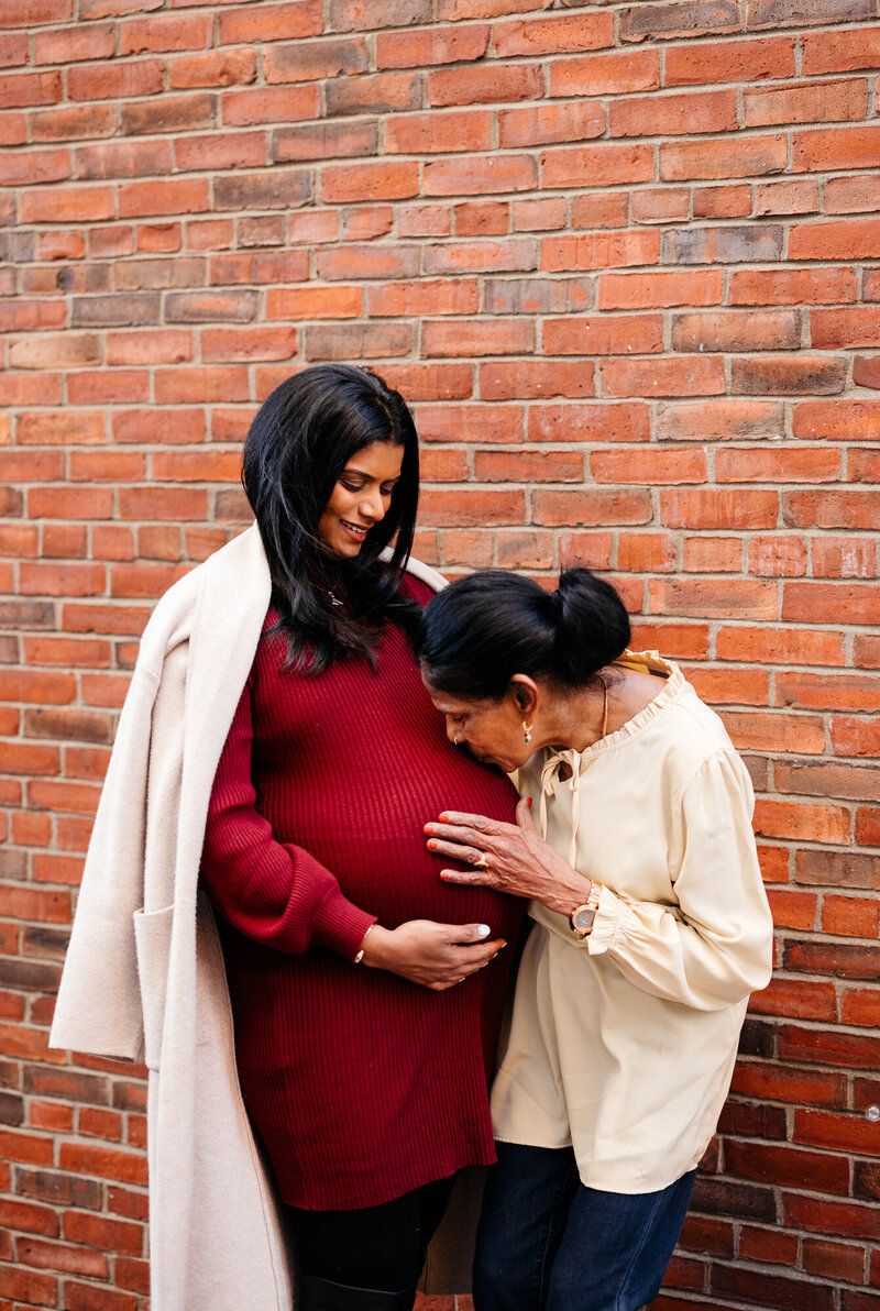 Sweet candid moments captured between a couple against red brick wall backdrop.