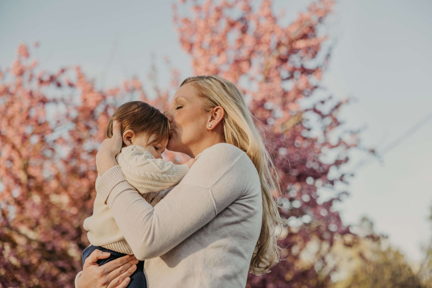Intimate portrait session among pink cherry blossoms.