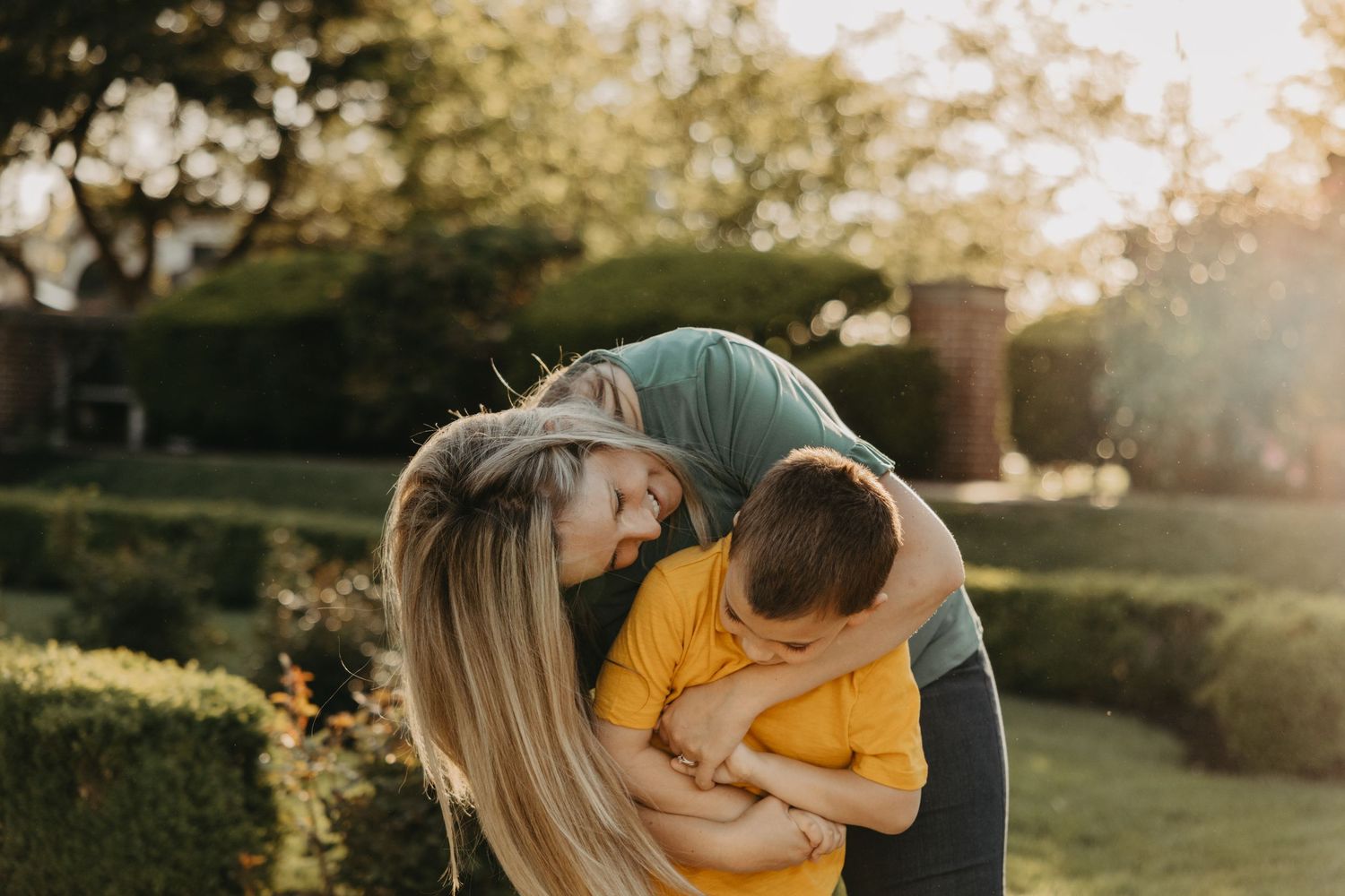 Family sharing joyful moments in a sunlit garden during golden hour.