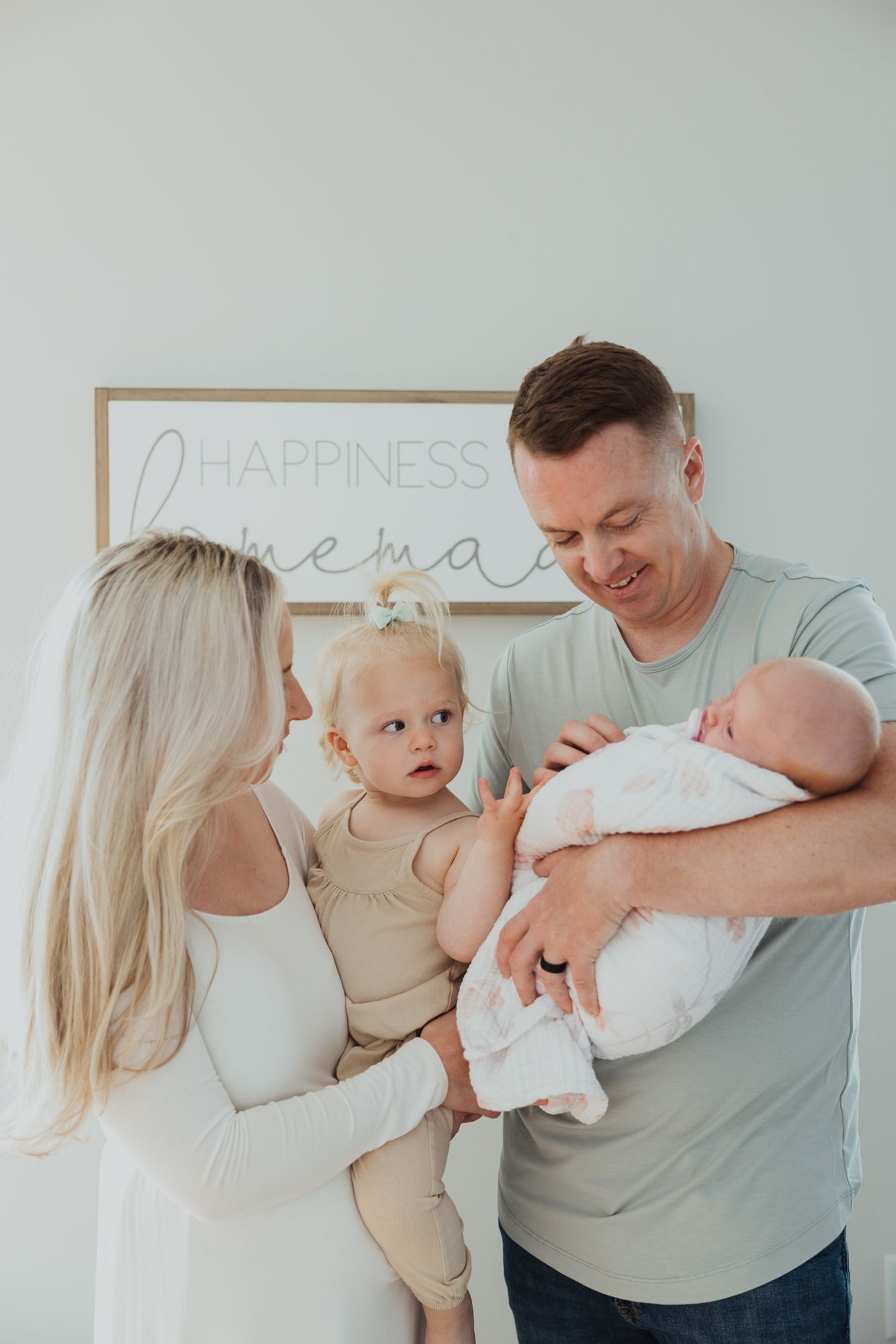 Candid family moments captured in sequence against light blue wall with decorative text sign.