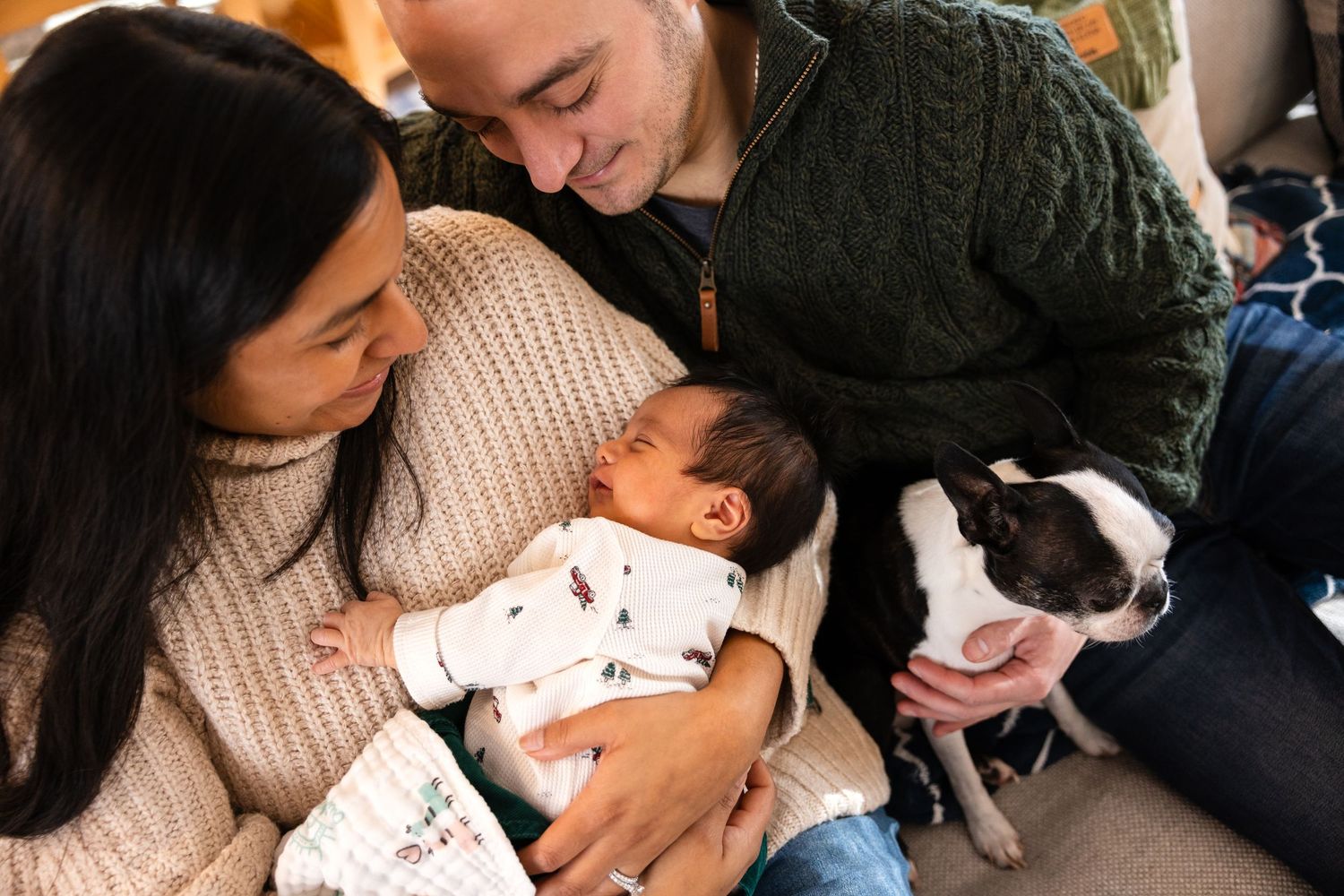 Family bonding moment with baby and dog on comfortable couch.