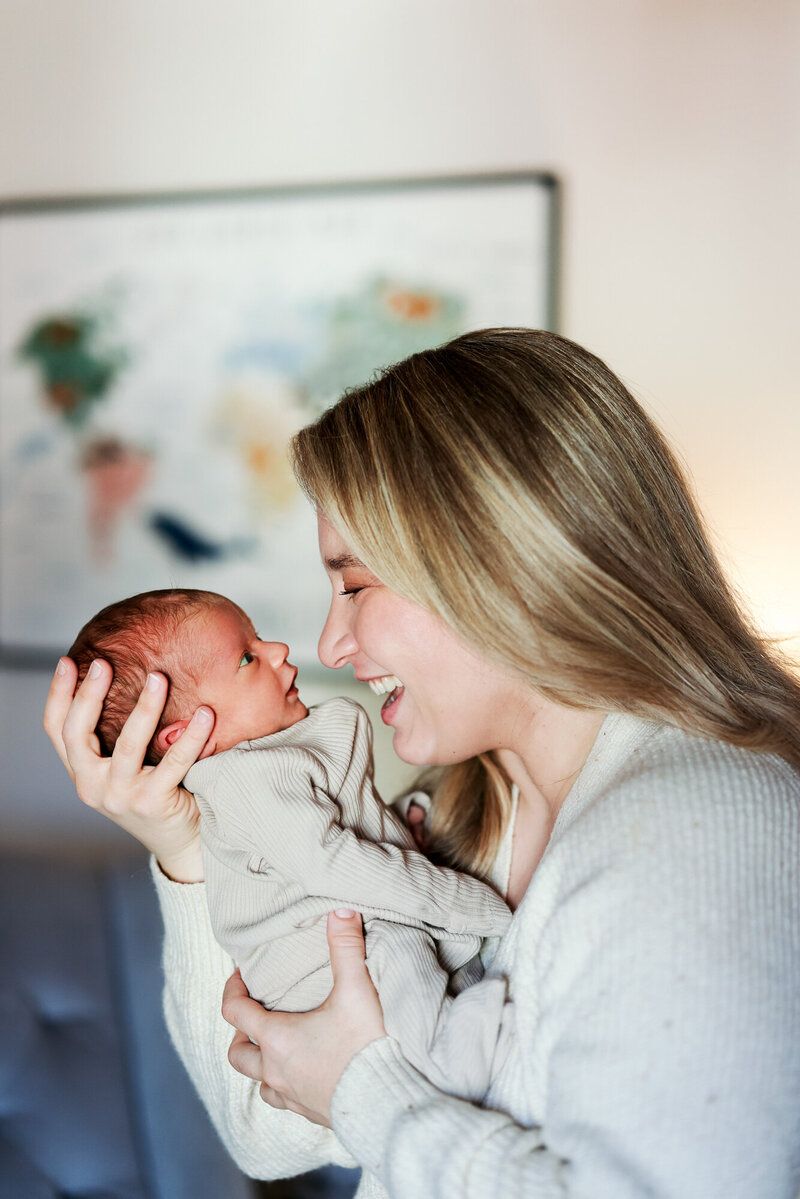 Tender moments between parent and newborn captured in soft profile shots.