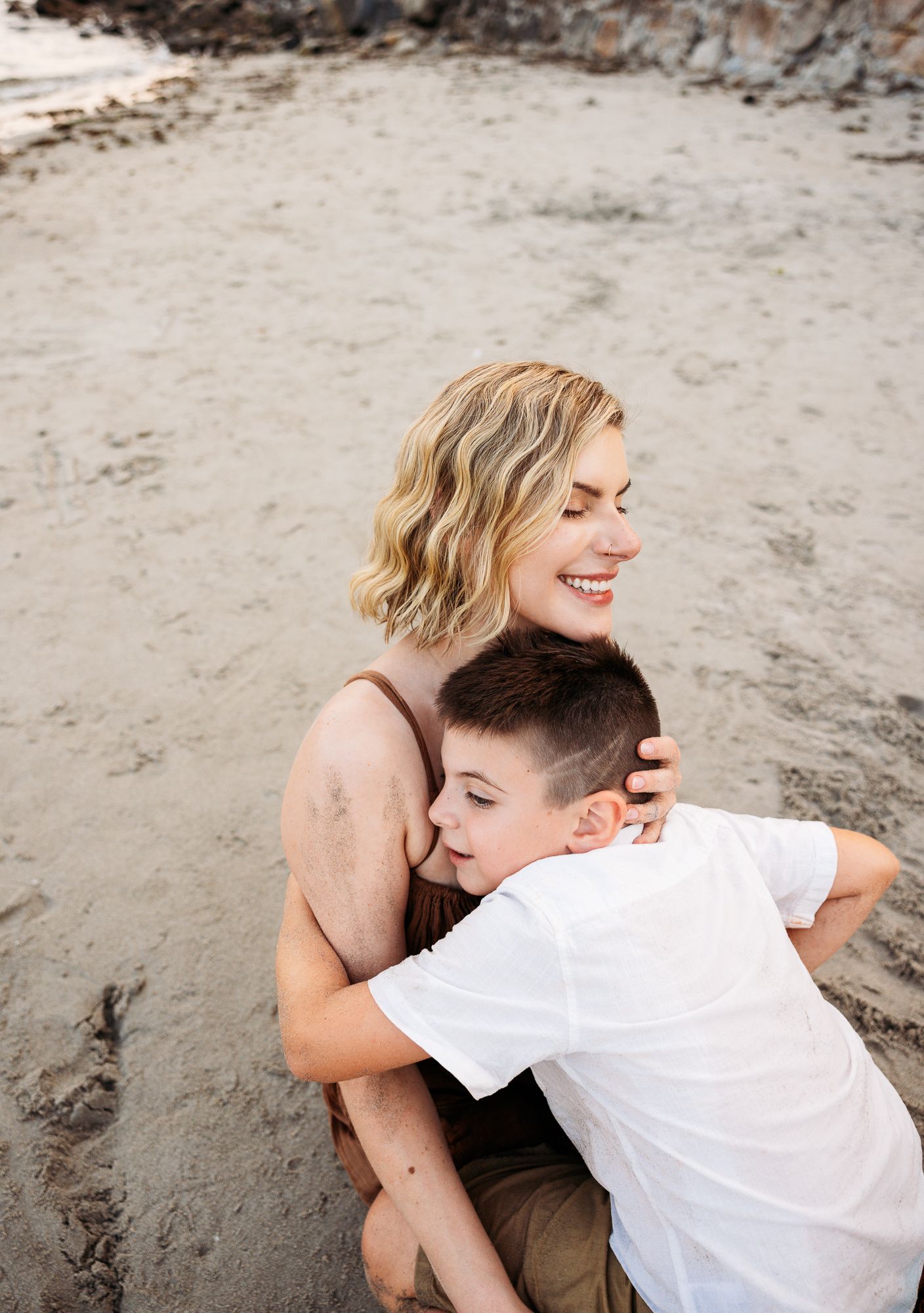 Candid beach photos showing playful interactions on sandy shore with gentle seaside lighting.