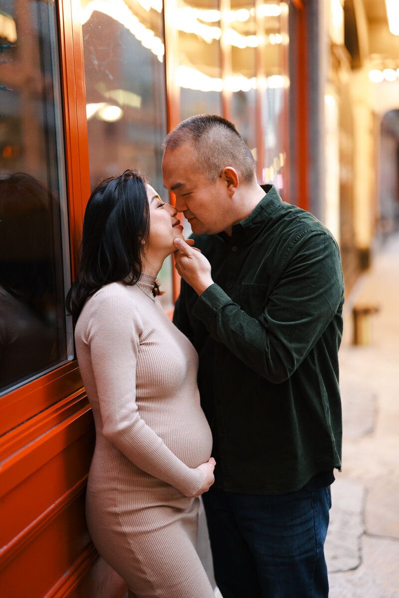 Intimate couple portraits with warm lighting against storefront windows.