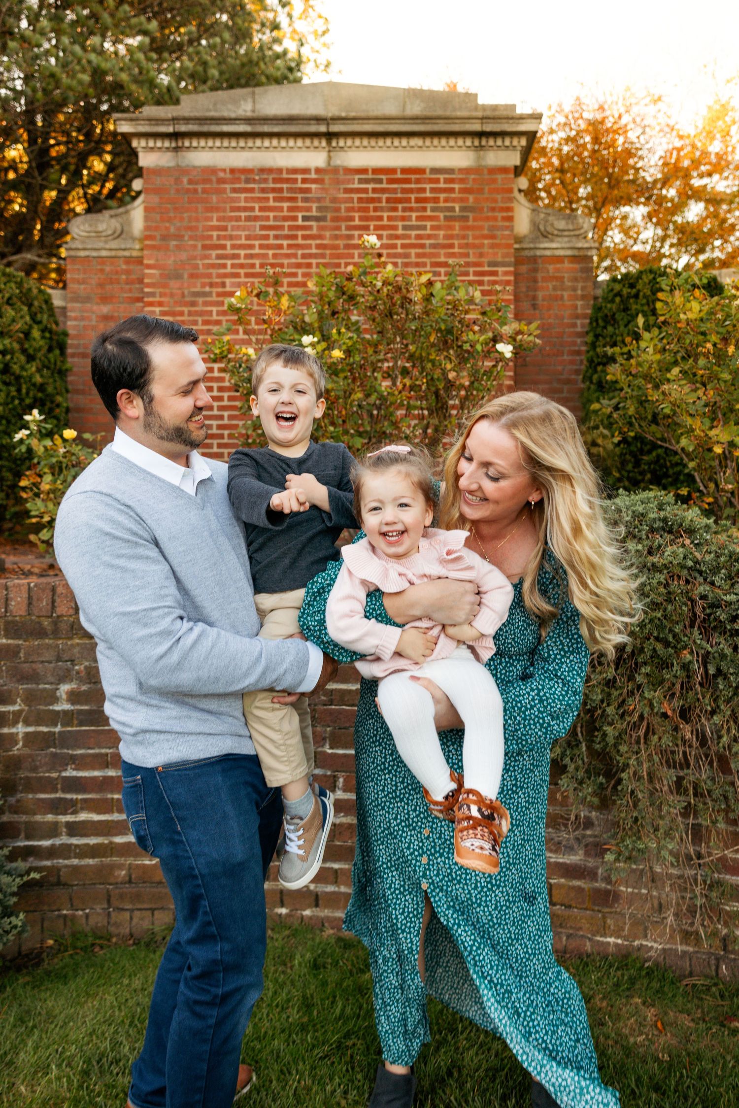 Joyful family interactions captured against a brick wall during an autumn photo session.