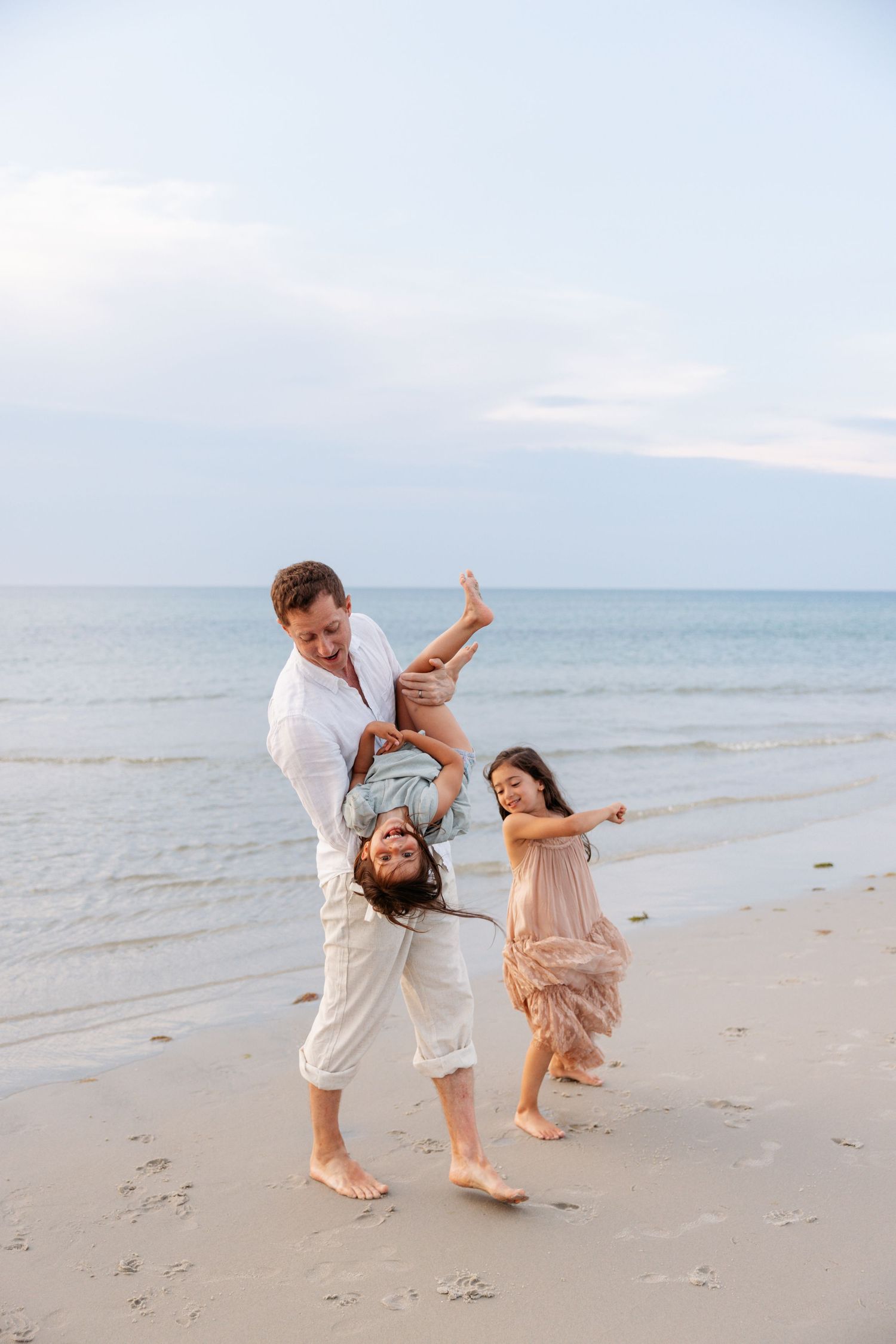 Dynamic beach photoshoot sequence showing playful interactions and movement against ocean backdrop.