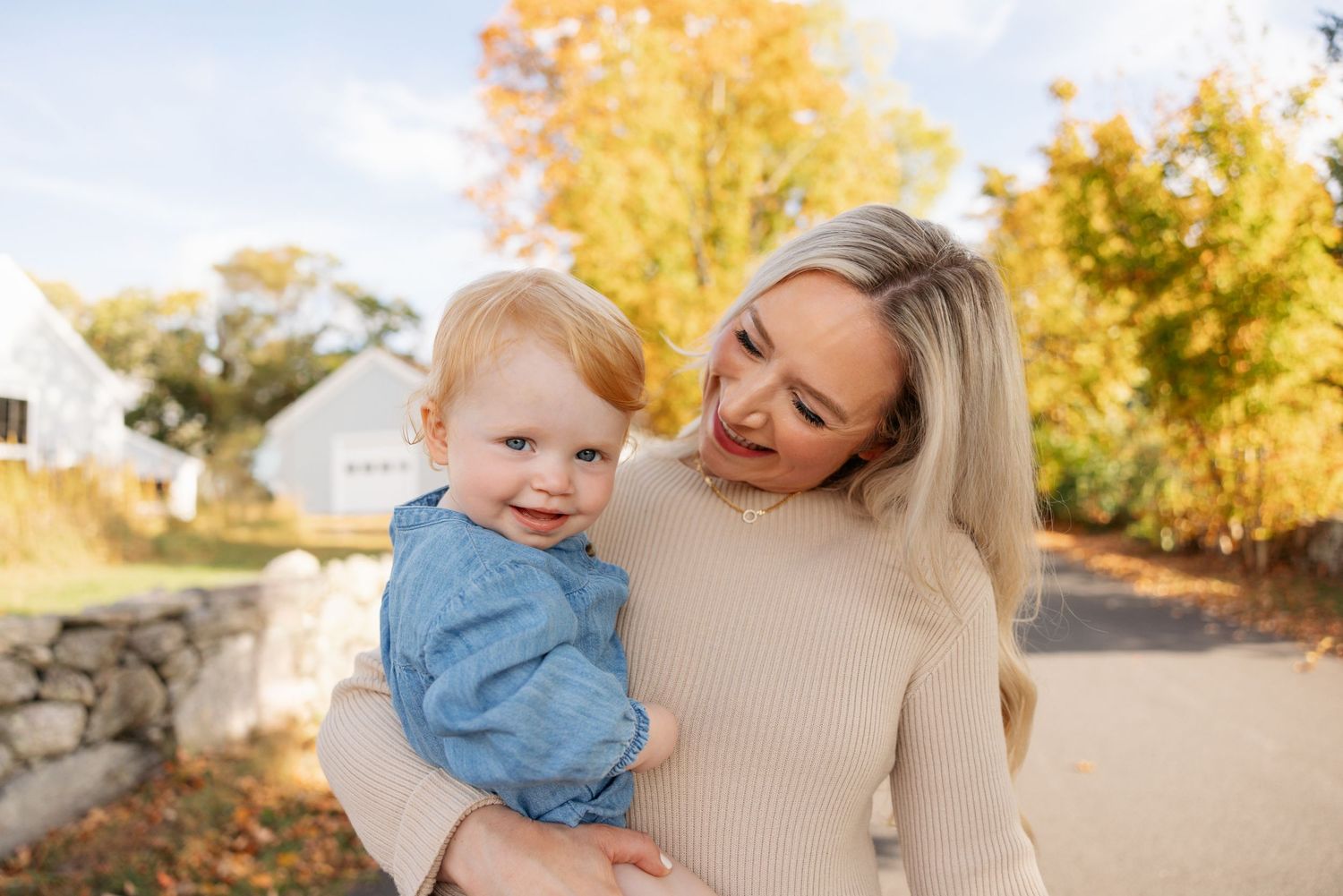 Family enjoying a warm autumn day together in a park with golden foliage in the background.