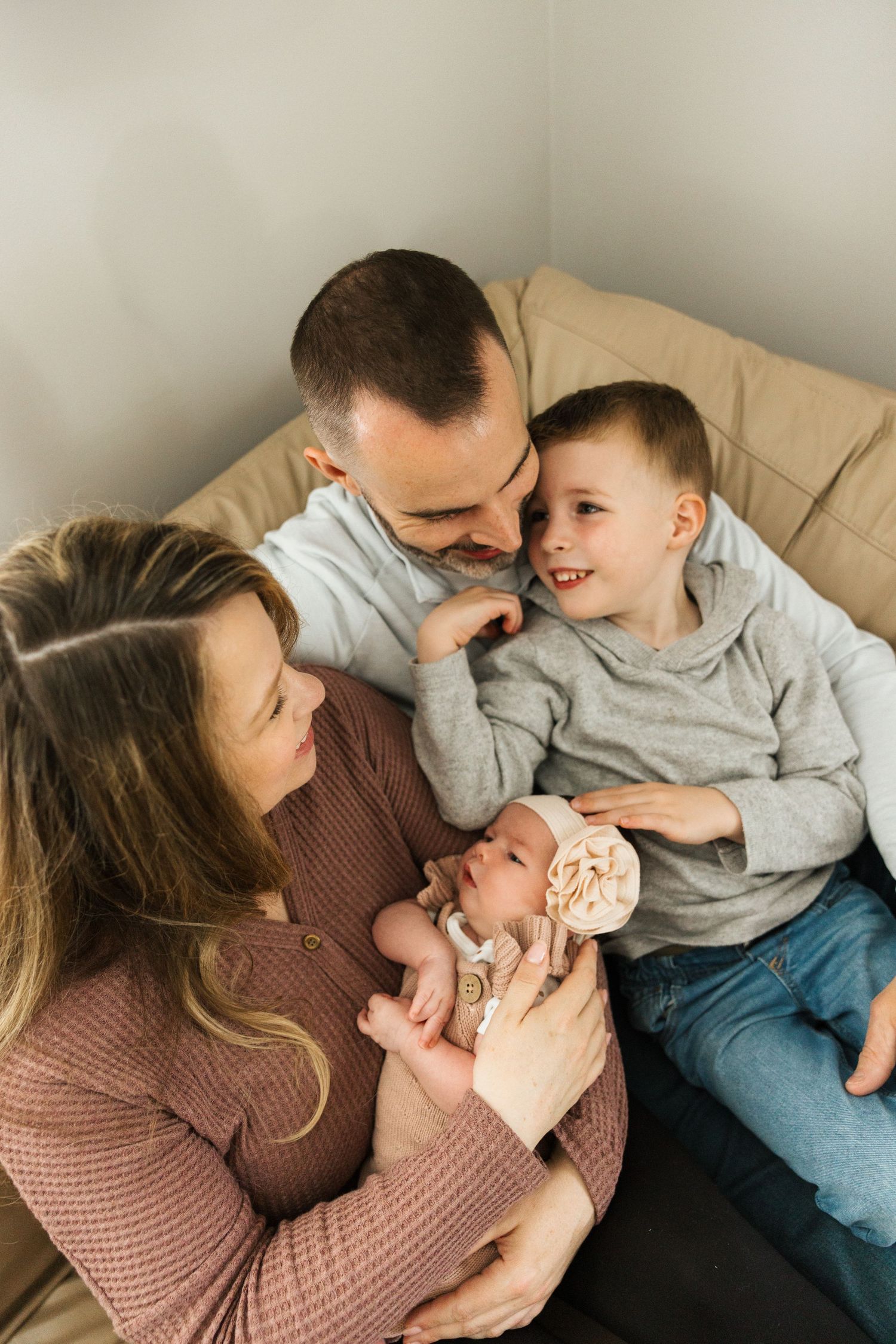 Family lifestyle photos showing tender moments as they cuddle together on a neutral colored couch.