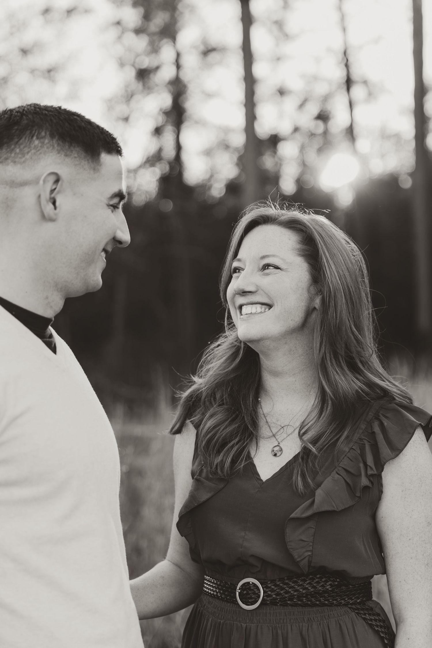 Couple looking at each other and smiling in field