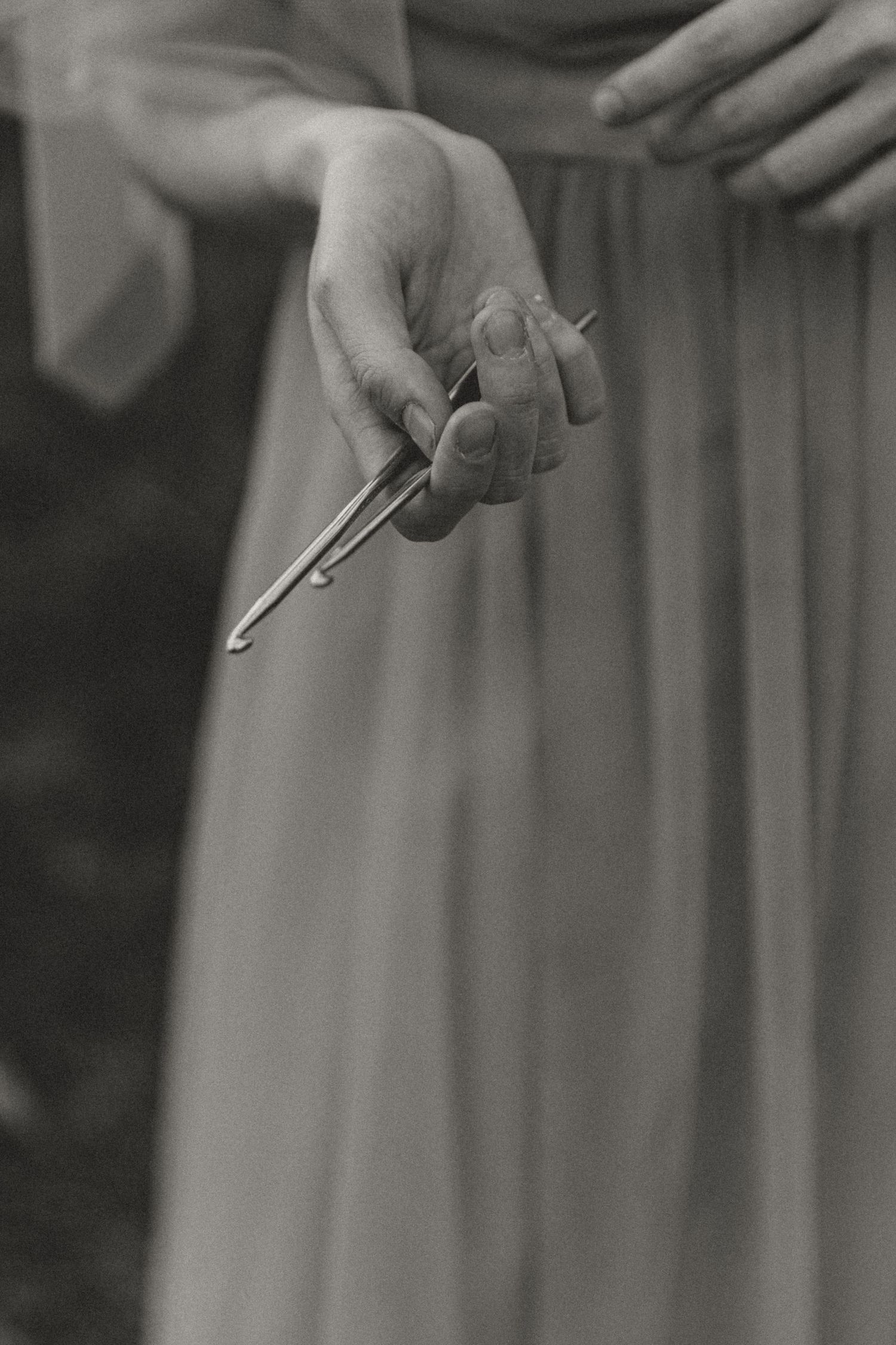 A series of black and white photographs showing hands holding knitting tools.