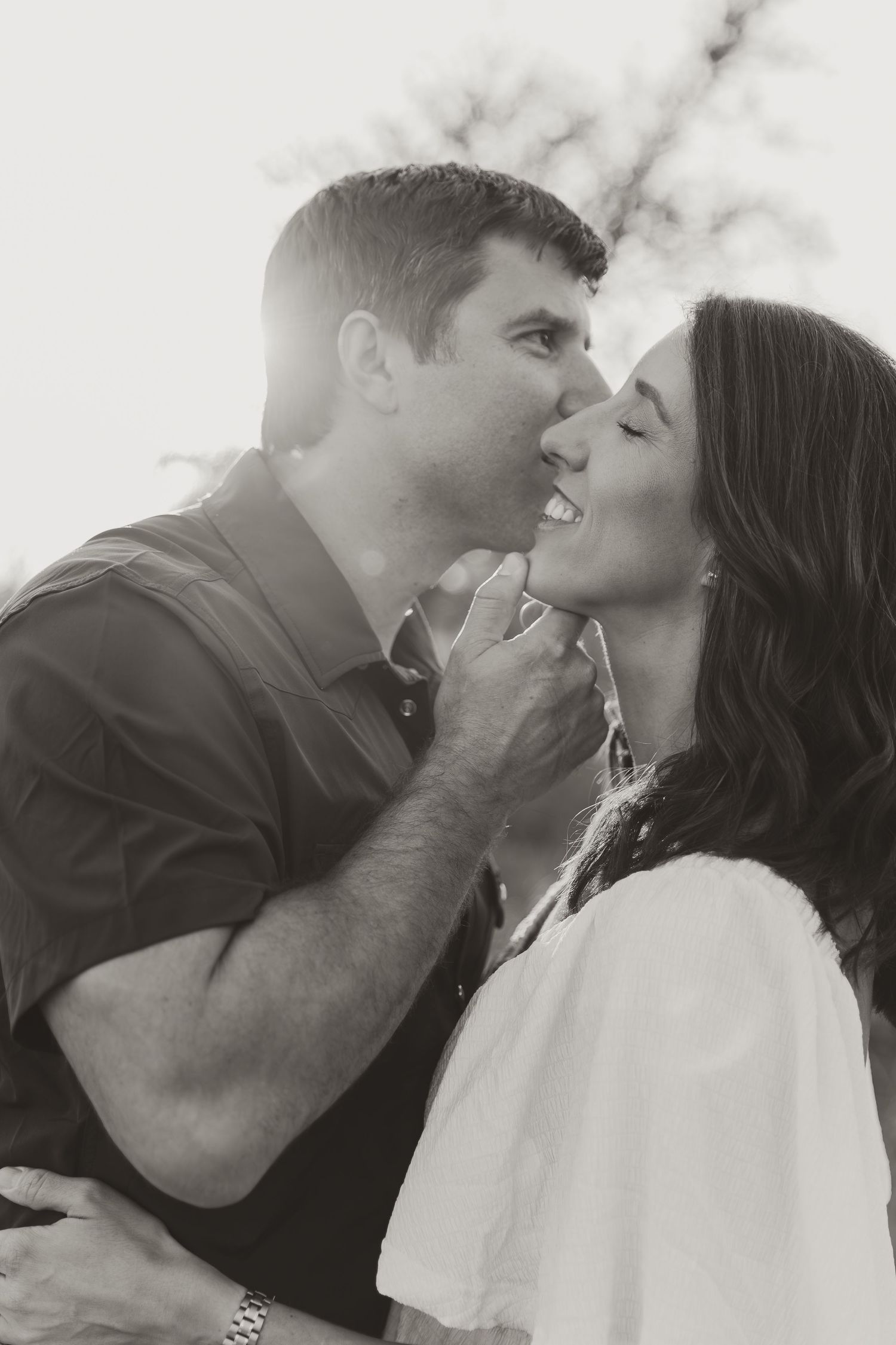 San Antonio couple at crescent bend nature park. he's kissing her cheek