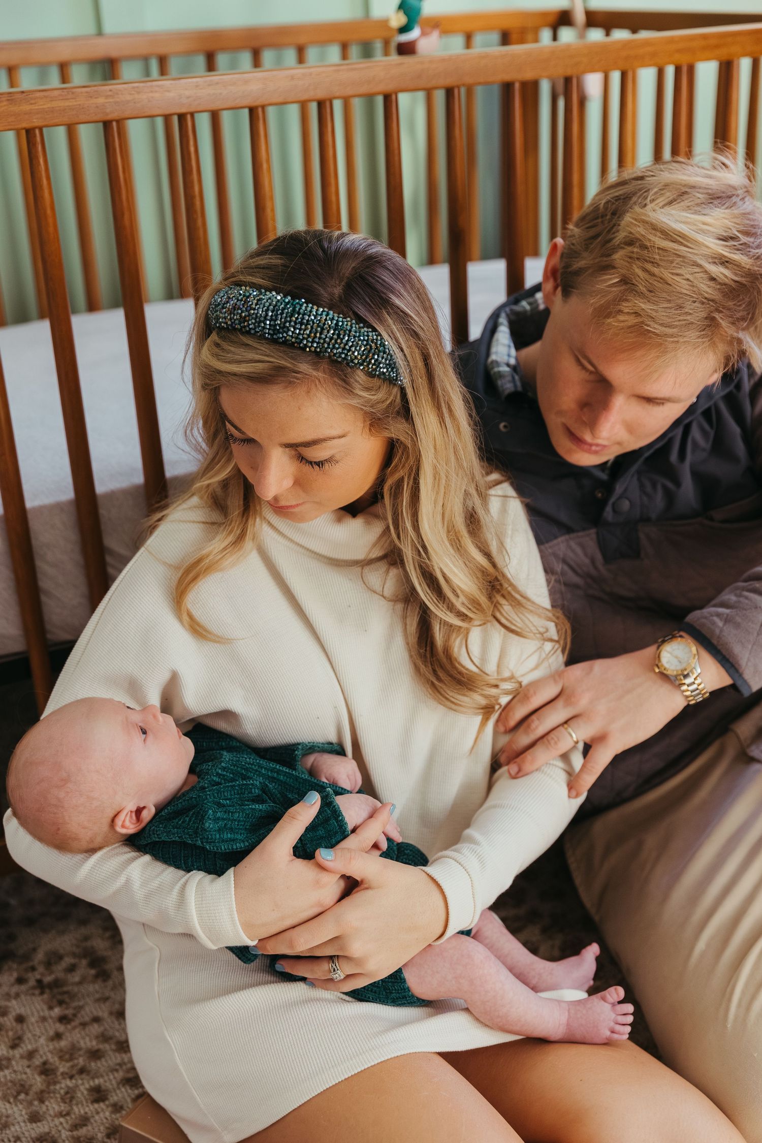 A series of tender moments showing a parent cradling and bonding with their newborn baby in a cozy nursery setting.