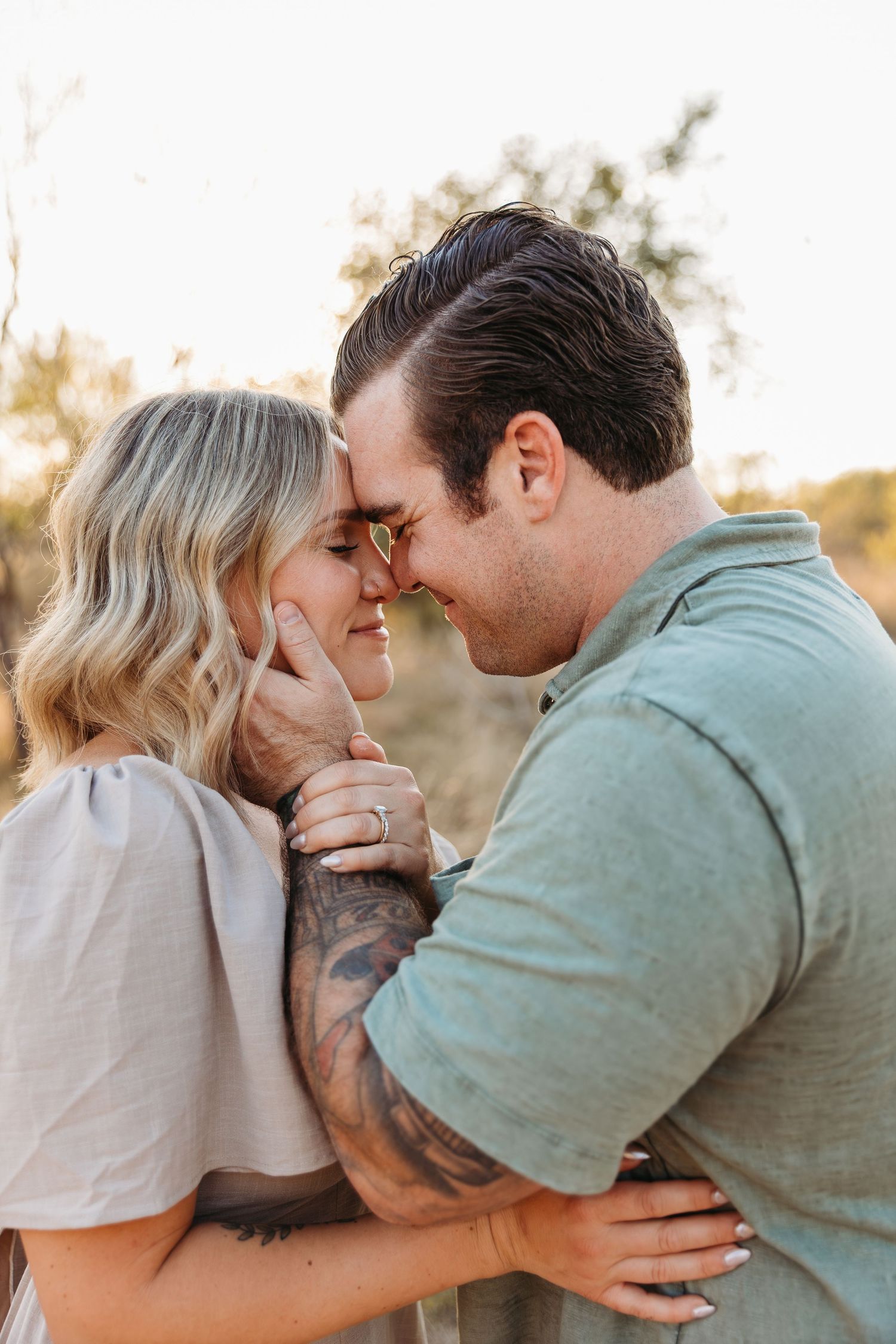 San Antonio couple forehead to forehead and smiling  at crescent bend nature park.
