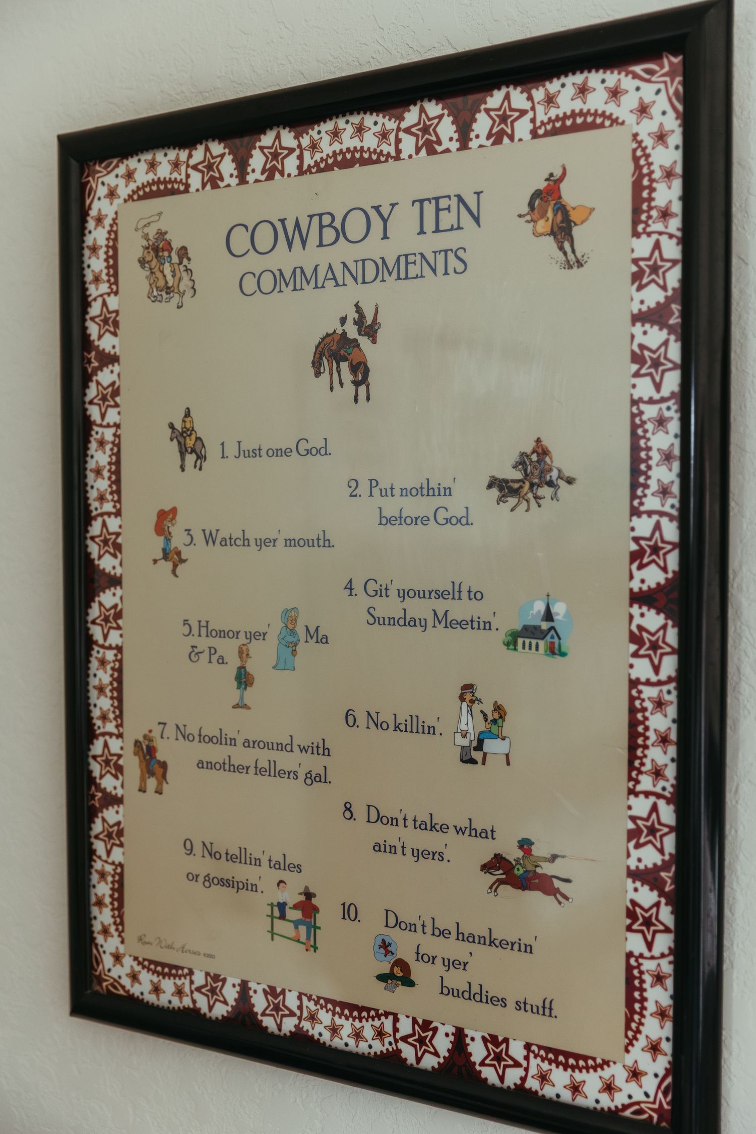 Framed wall art displaying the Cowboy Ten Commandments with western-themed illustrations and decorative border.