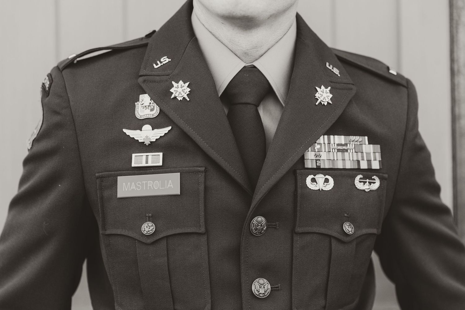 A military service member in dress uniforms with medals and insignia for a formal photograph.