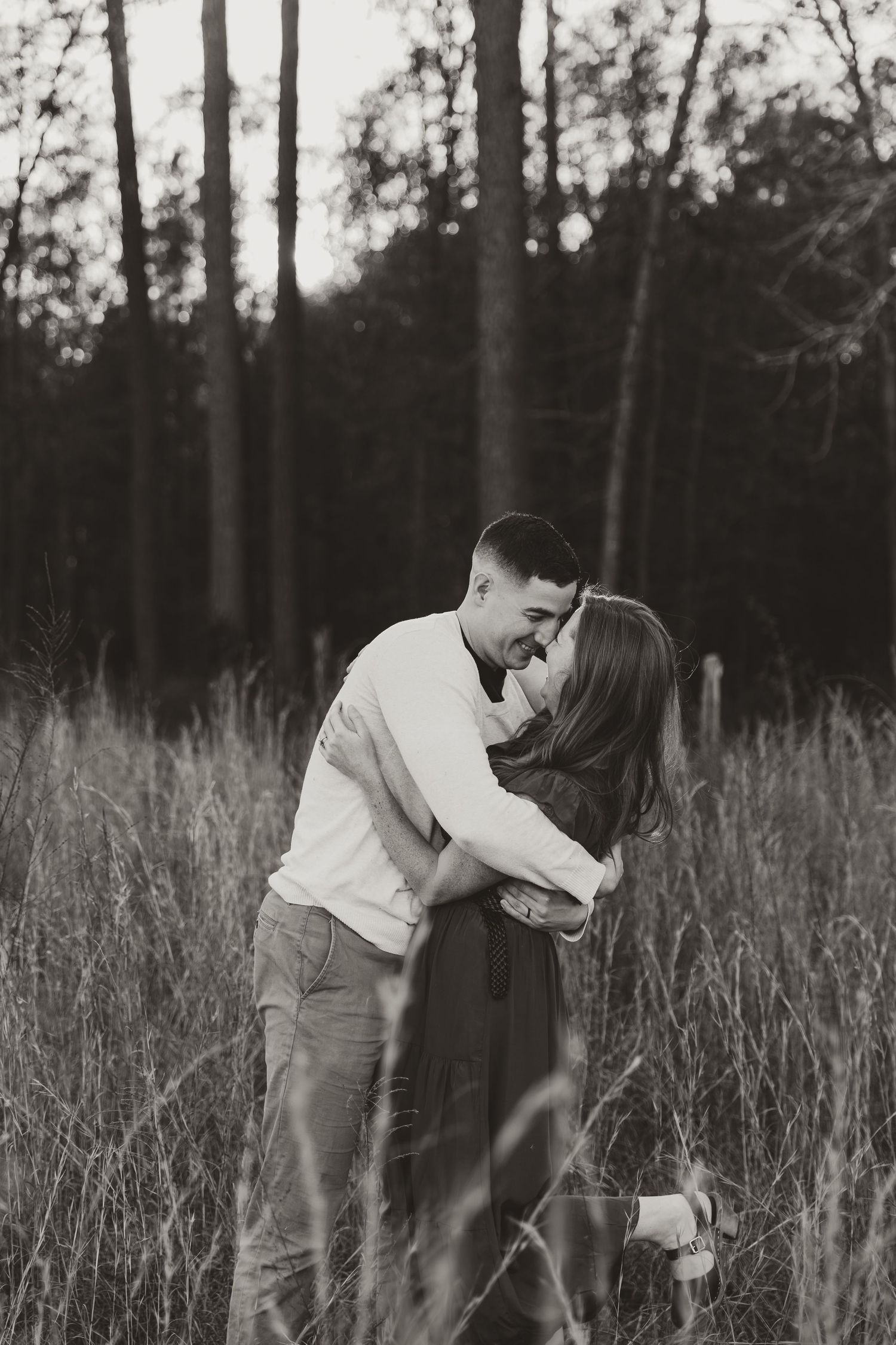 San Antonio couple hugging and smiling in tall field of grass