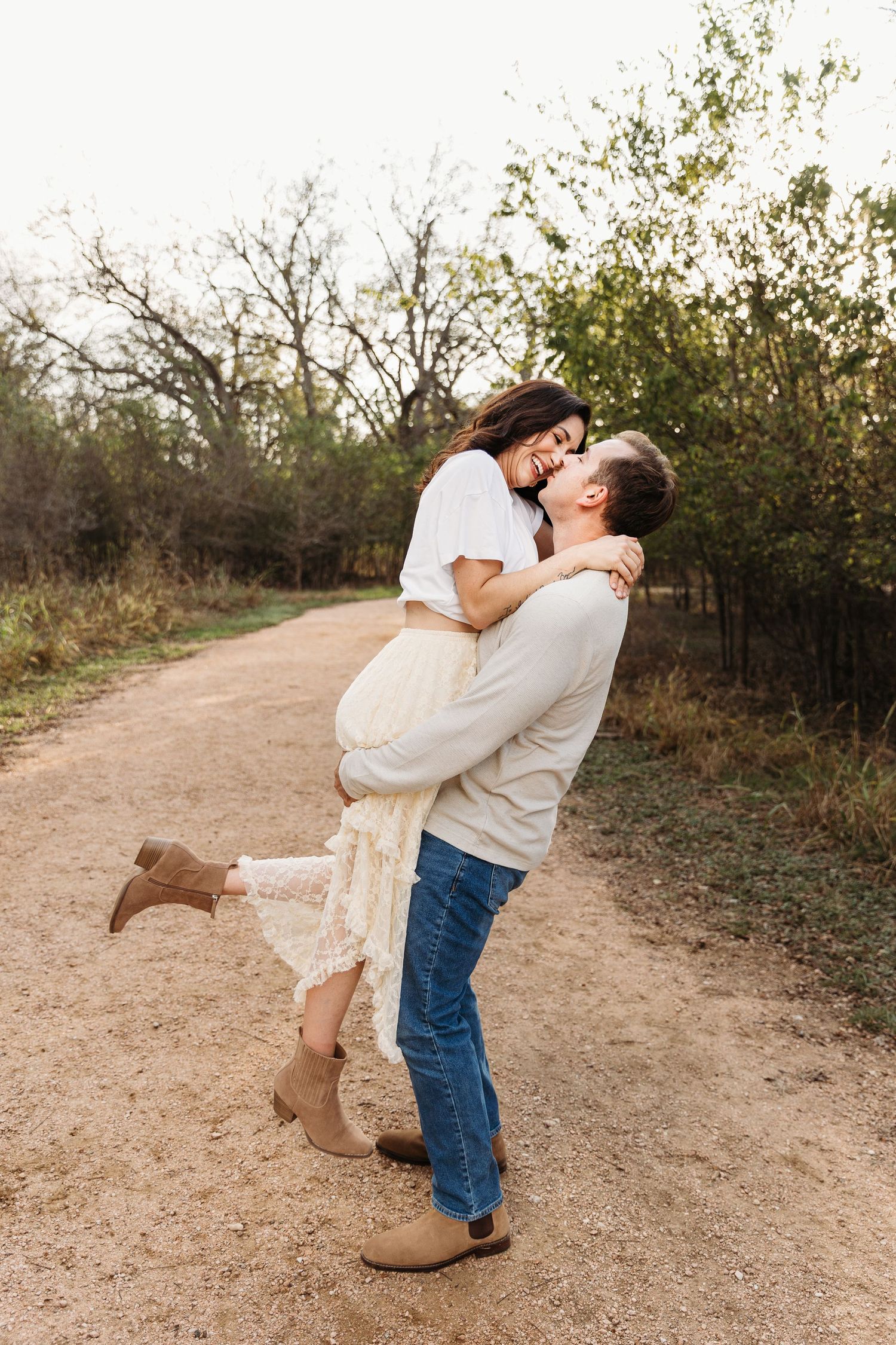 San Antonio couple at crescent bend nature park. He is picking her up and holding her