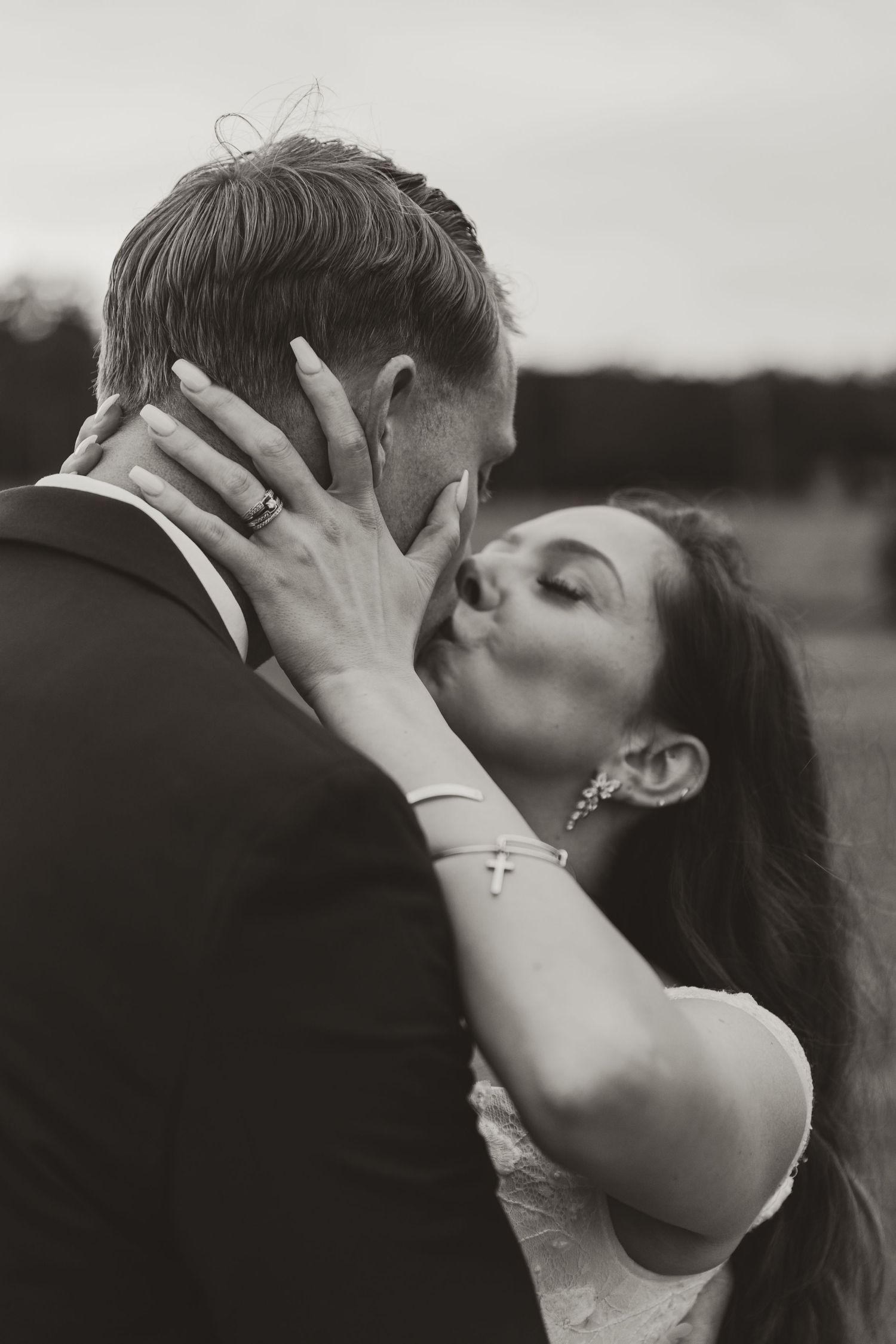 A romantic black and white photo sequence shows a couple sharing an intimate kiss outdoors.