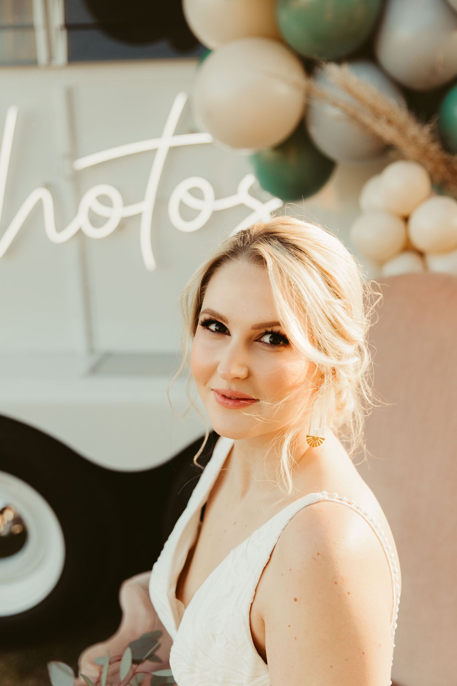 a photo showing a person in a white dress with soft lighting and balloon decorations.