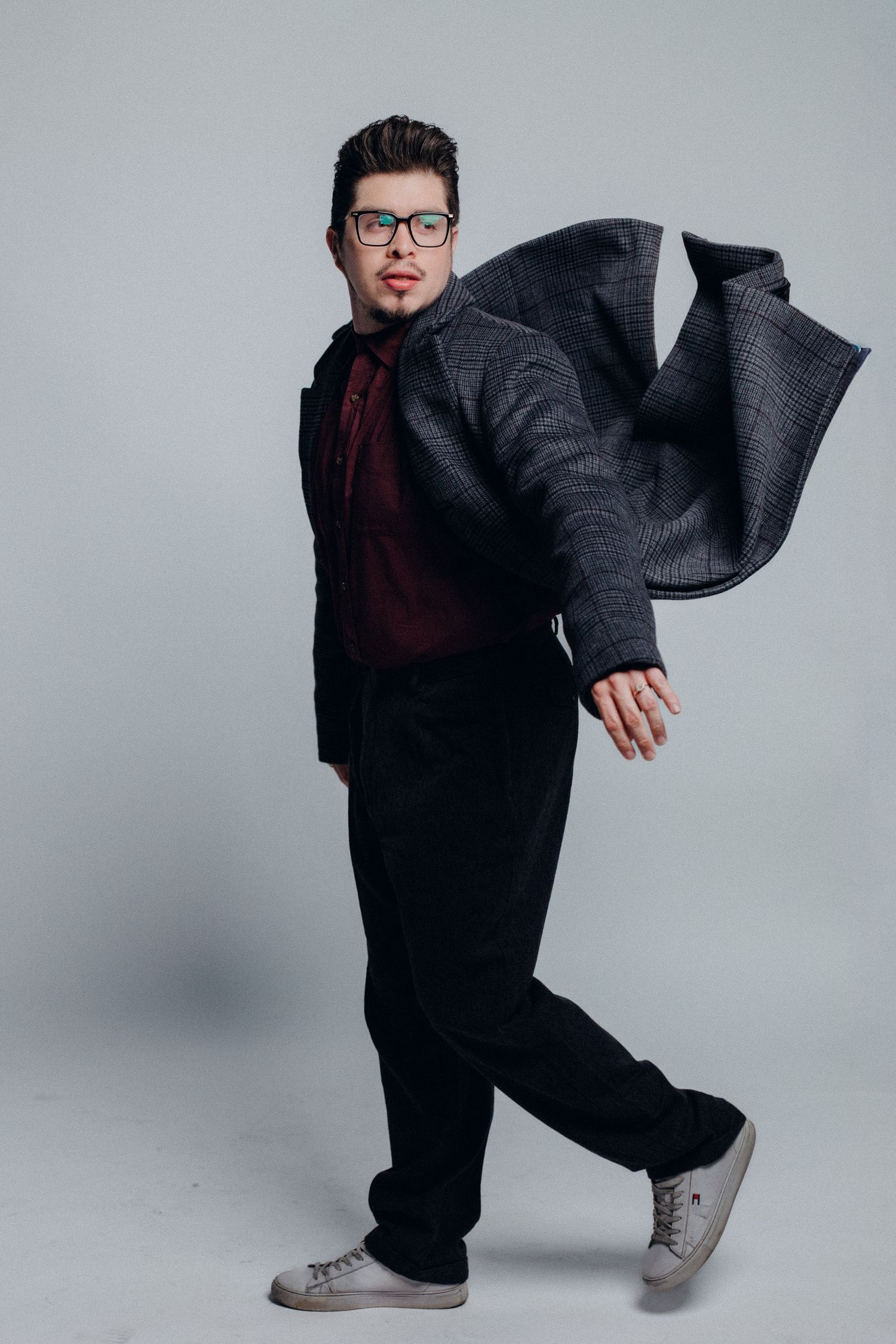 A dynamic fashion photo sequence showing a person in black clothing and gray sneakers posing against a light background.