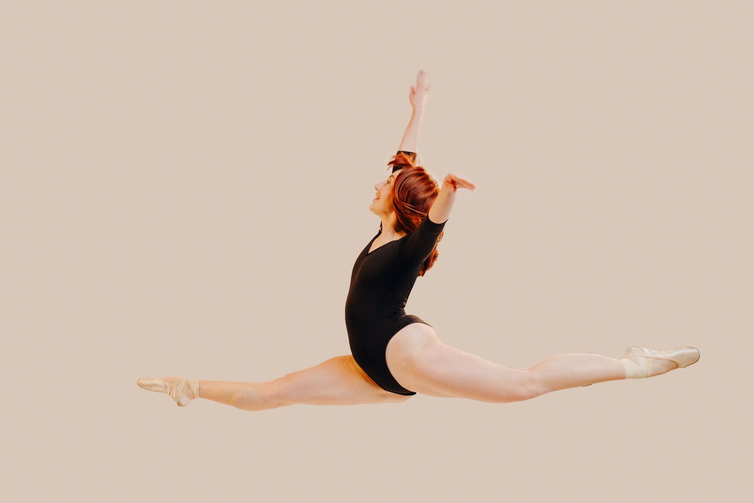 Dancer in black leotard performs graceful leaps against beige background.
