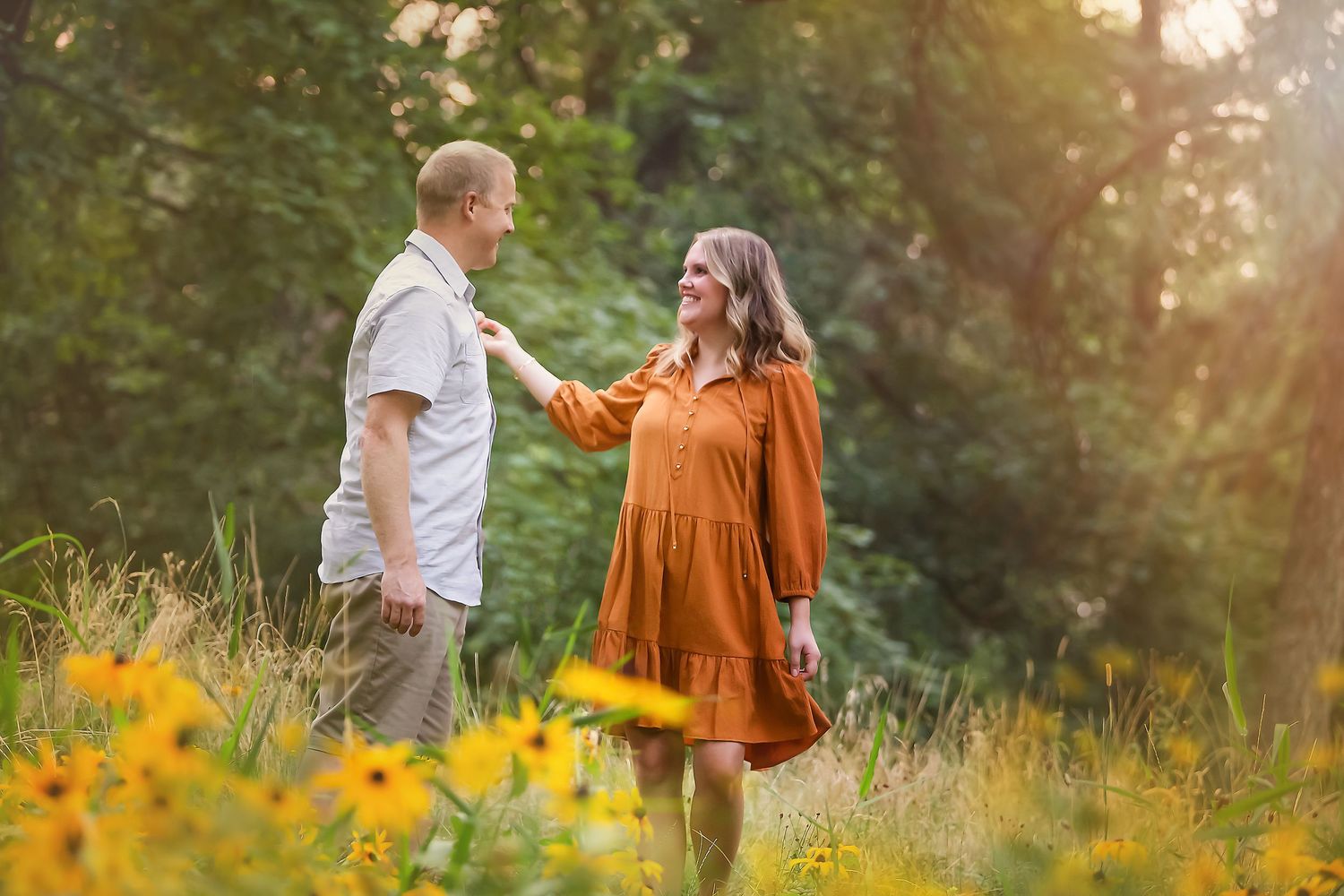 Family walking through sunlit field with yellow wildflowers.
