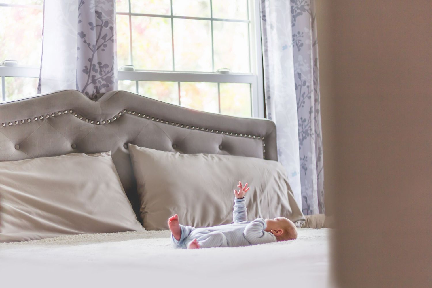 Interior bedroom scene with soft natural window light and upholstered headboard.