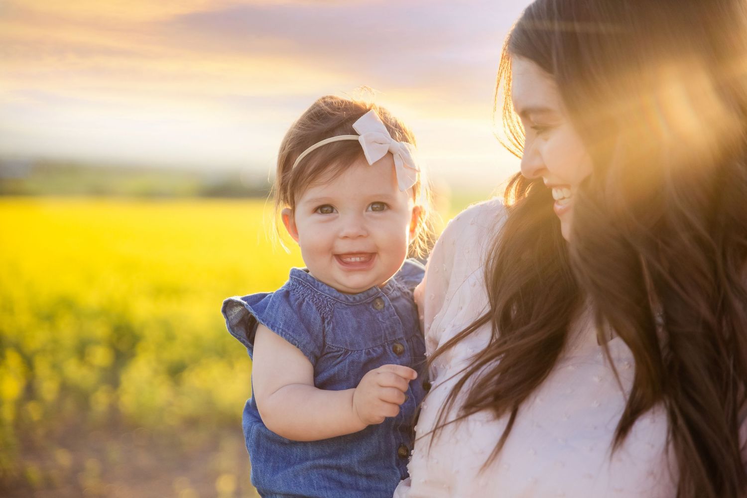 Golden hour portrait session in blooming yellow canola field.