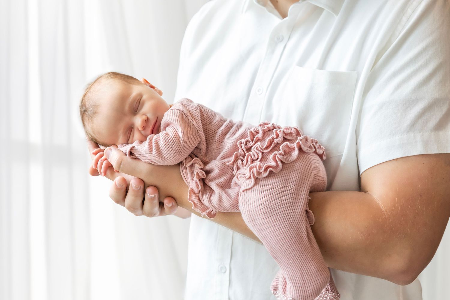 A series of images showing a baby in a pink dress being held and playing with someone in a white shirt.