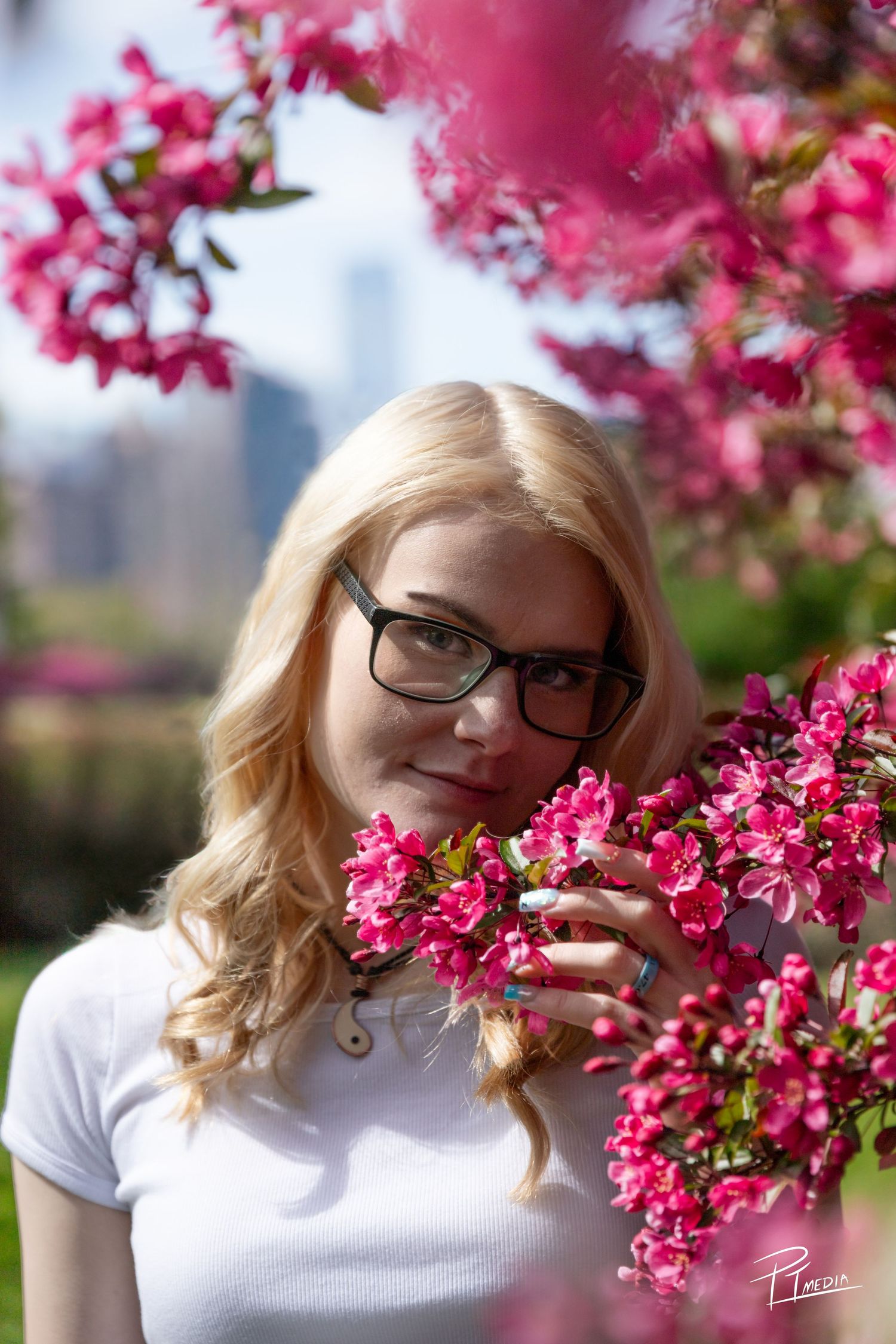 Beautiful spring blossoms frame a portrait against a soft blurred background in a natural outdoor setting.