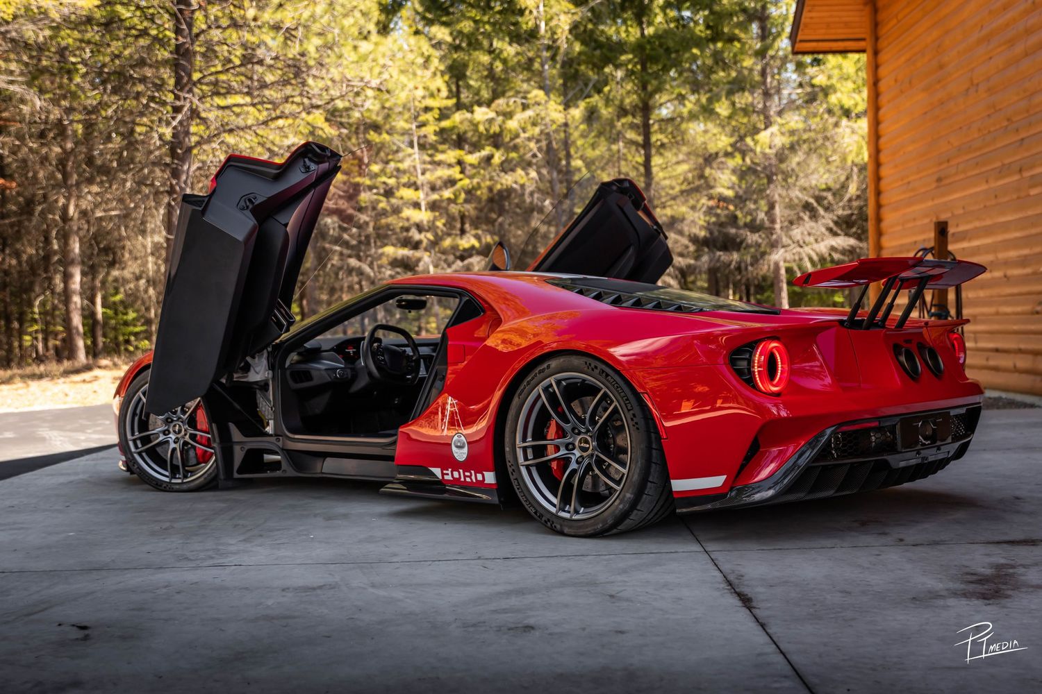 A red Ferrari SF90 Stradale supercar showcased from multiple angles in a wooded outdoor setting.