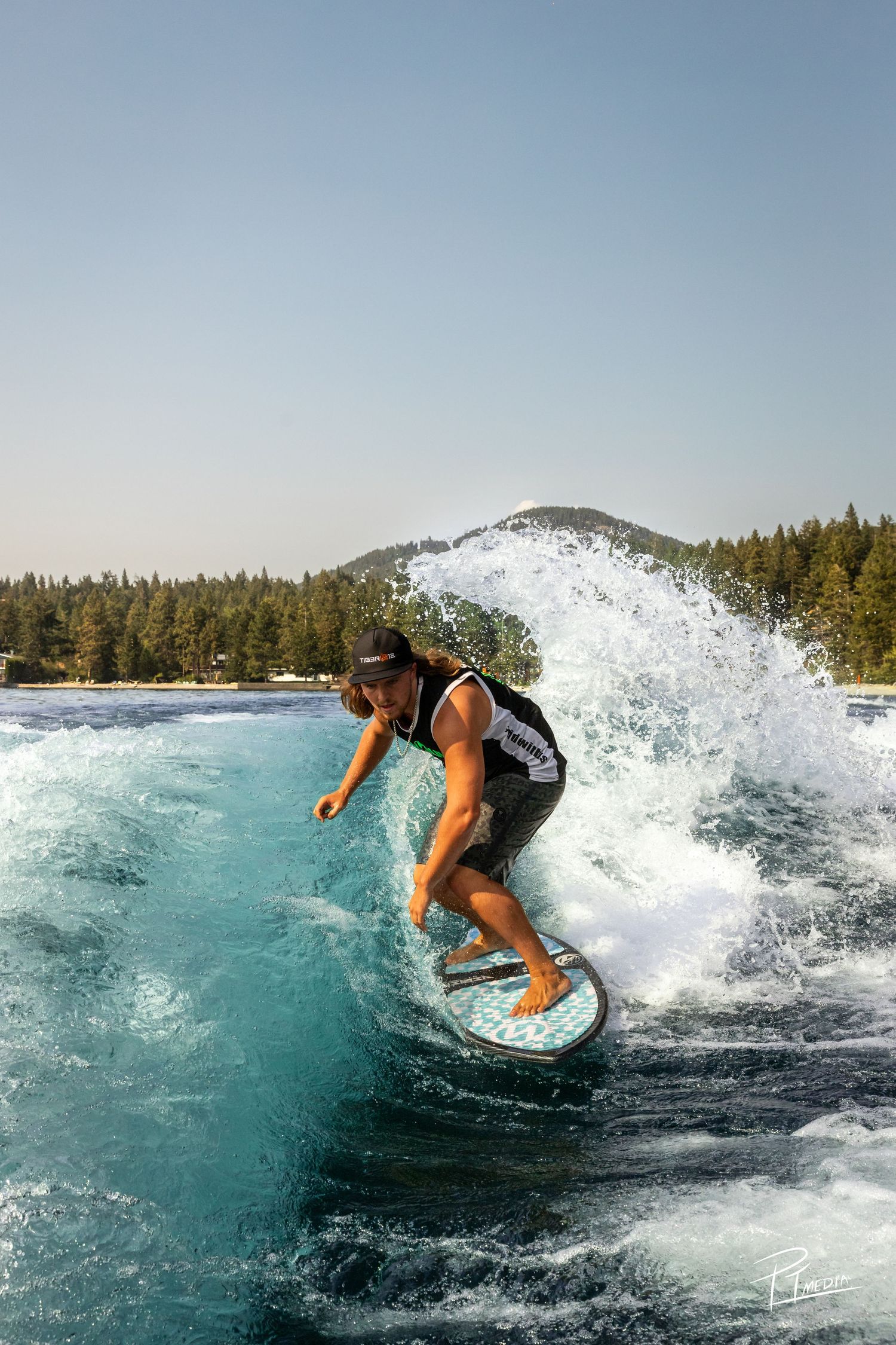 A wakeboarder performs dynamic turns and maneuvers creating dramatic splashes on bright turquoise tropical waters.