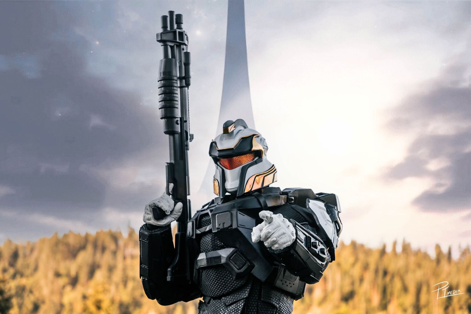 Silhouette of a person holding a rifle against a dramatic sunset with mountains and forest in the background.