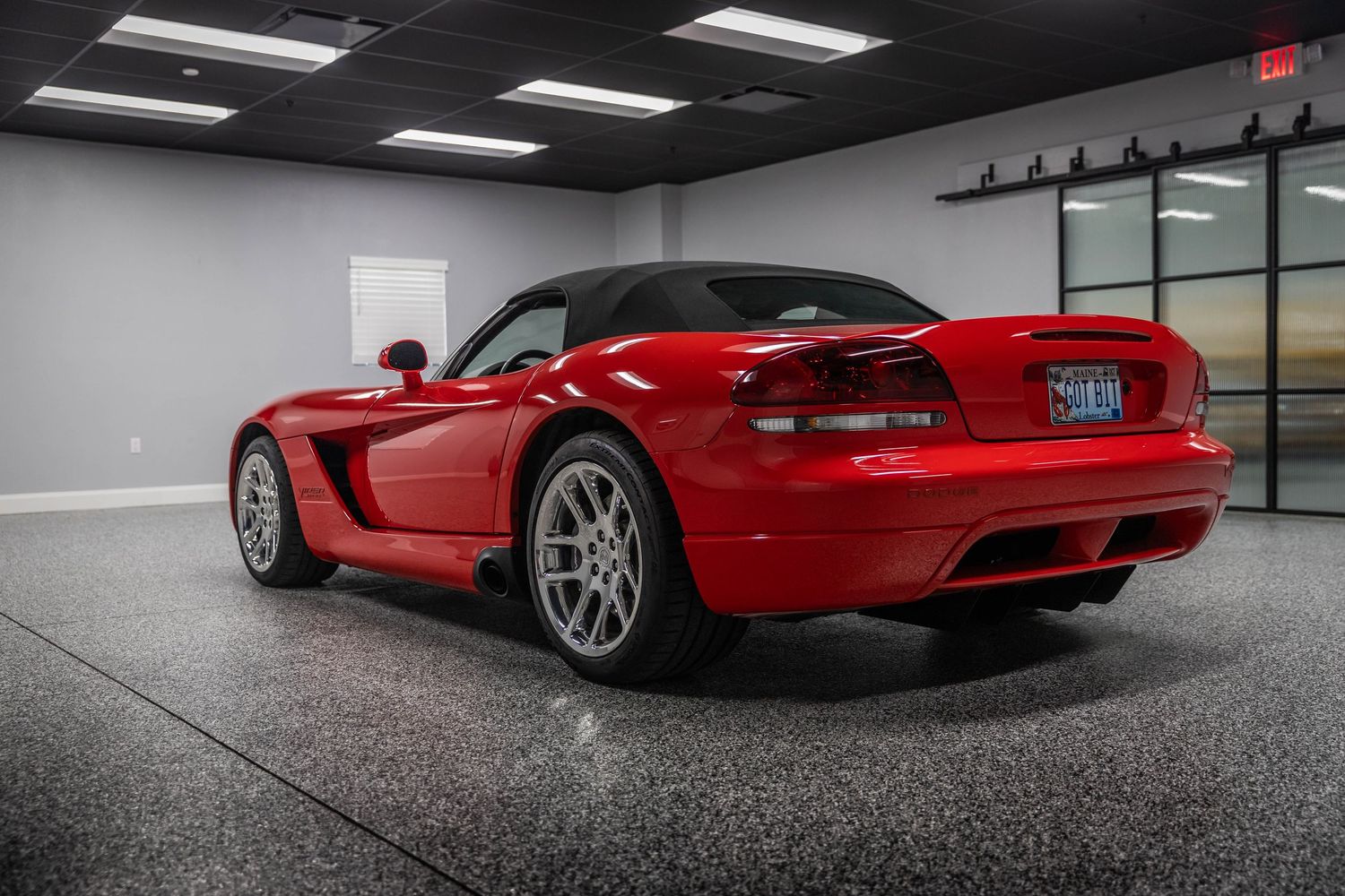 A red Dodge Viper sports car shown from multiple angles in a sleek indoor showroom setting.