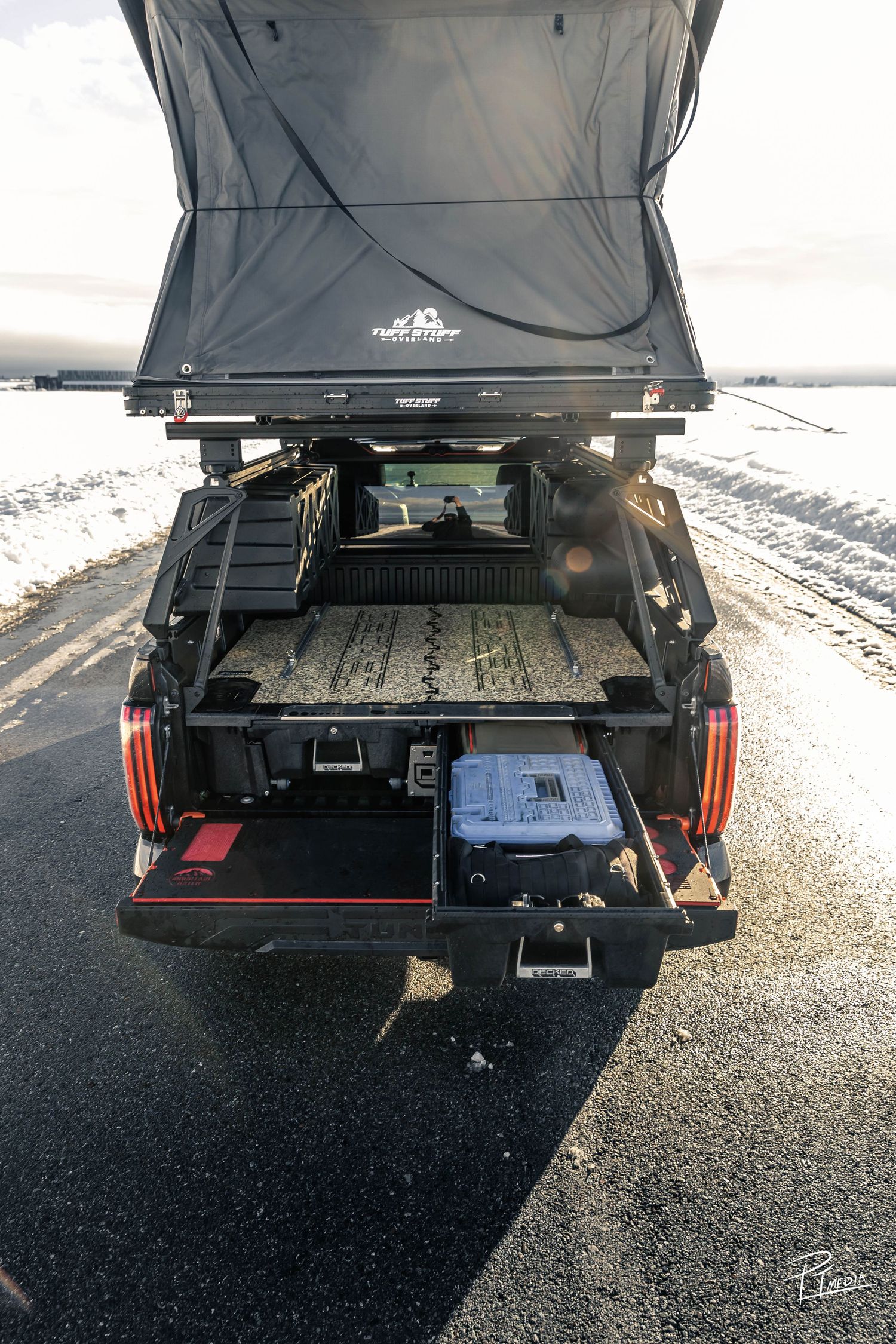 Multiple views of a black pickup truck bed showing sliding storage drawers and cargo organization system.