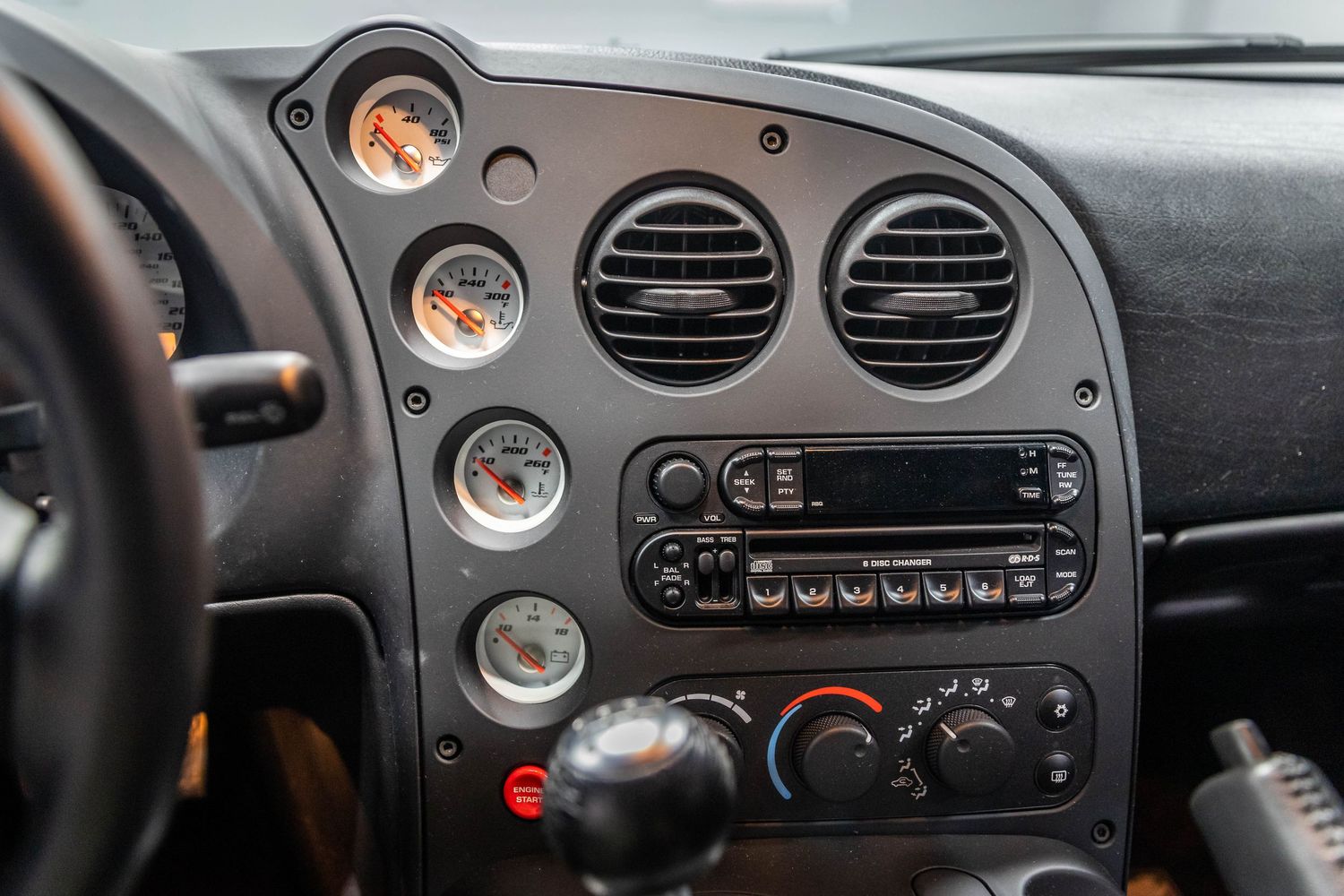 Car dashboard showing stereo system and air vents in a dark interior with orange gauge lighting.