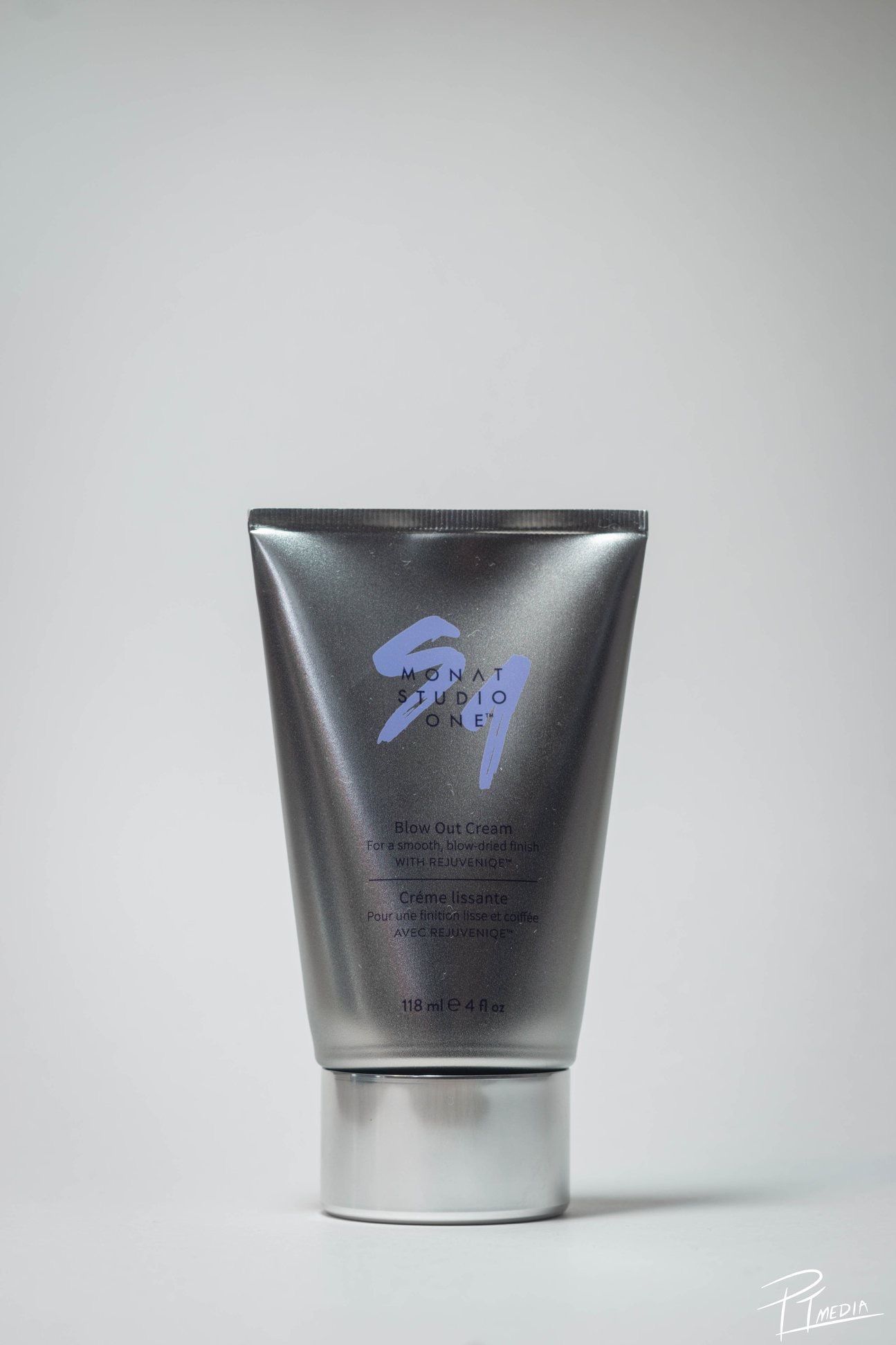 Three views of a sleek silver metallic cosmetic product container with blue text against a light gray background.