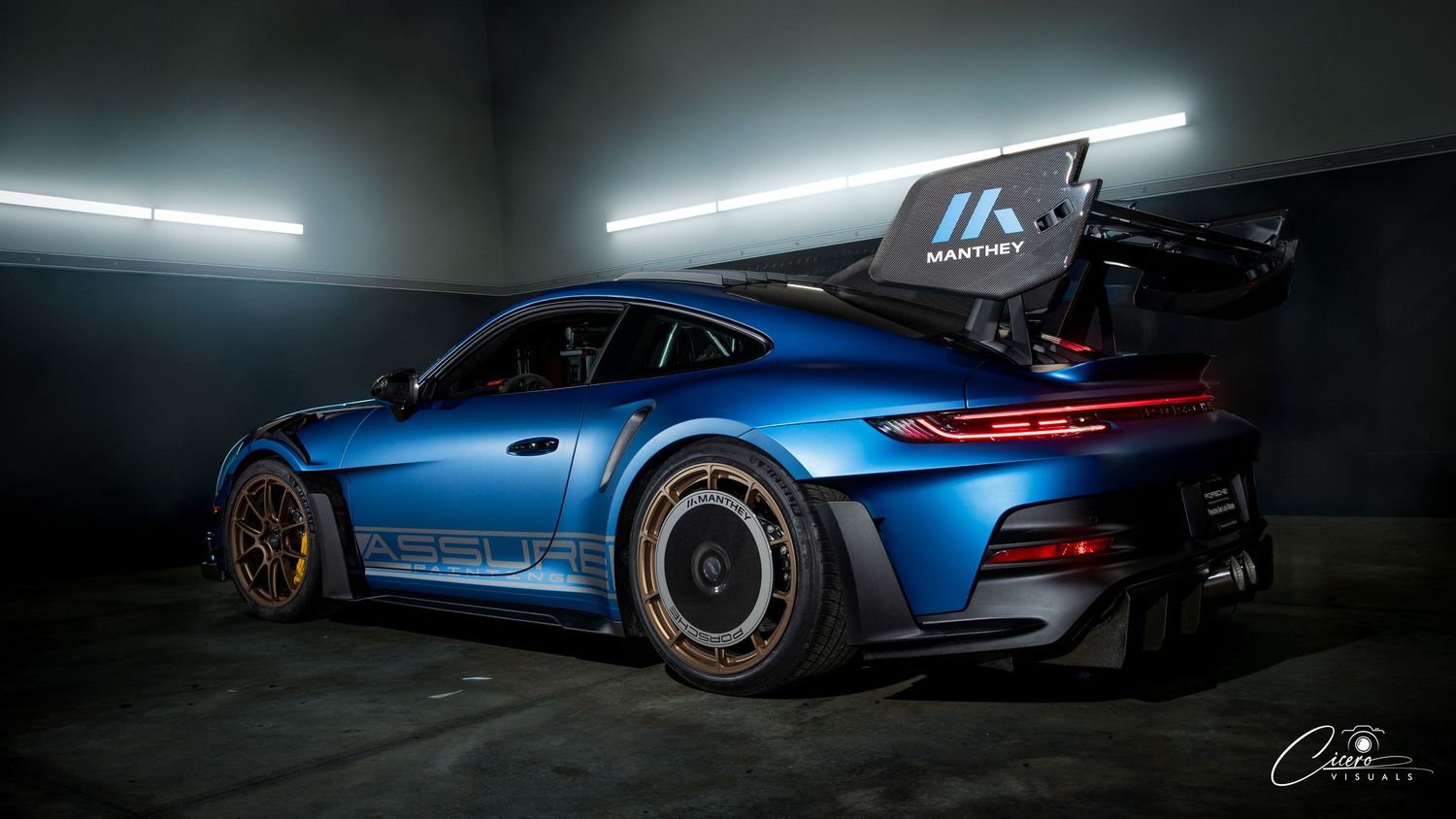 A sleek blue Porsche 911 GT3 RS is showcased in dramatic low-light studio photography with glowing LED strips in Coeur d' Alene, Idaho.