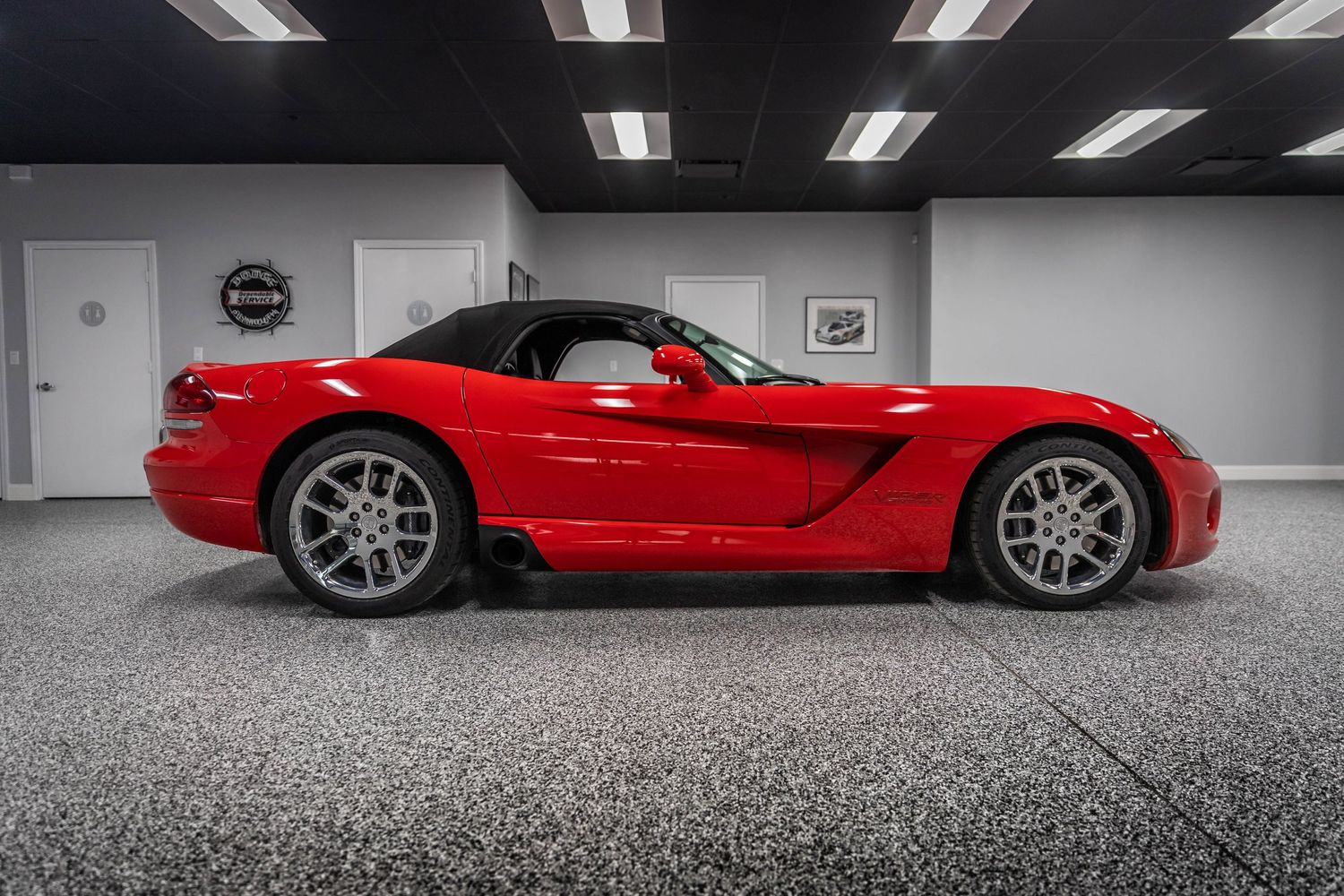 A bright red Chevrolet Corvette C8 supercar shown in multiple angles inside a sleek modern showroom.
