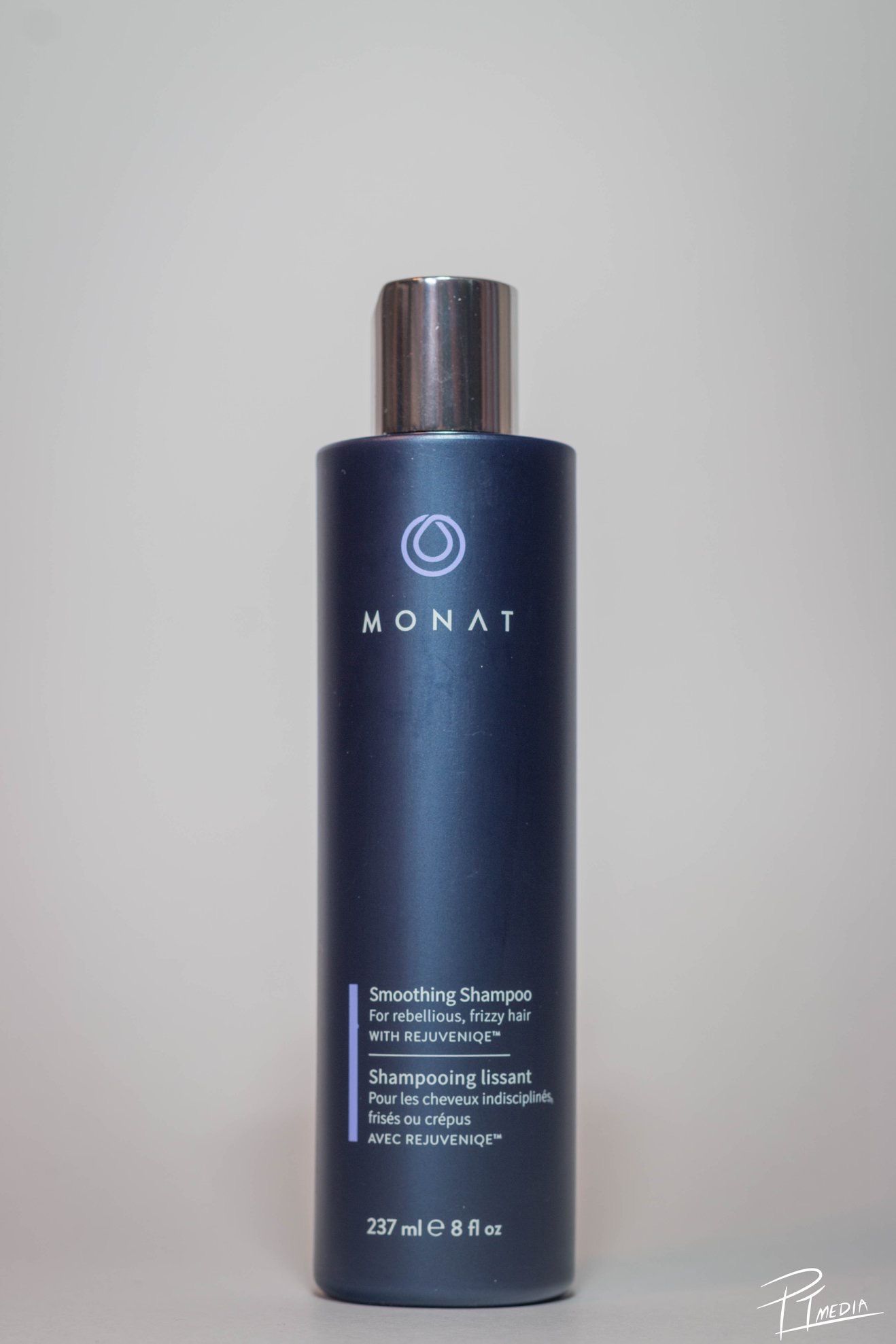 Navy blue Monat hair smoothing shampoo bottle shown from multiple angles against a white background.