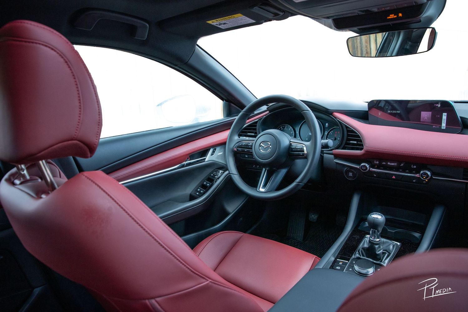 Modern Mazda interior featuring luxurious red leather seats and a sleek black dashboard with digital displays.