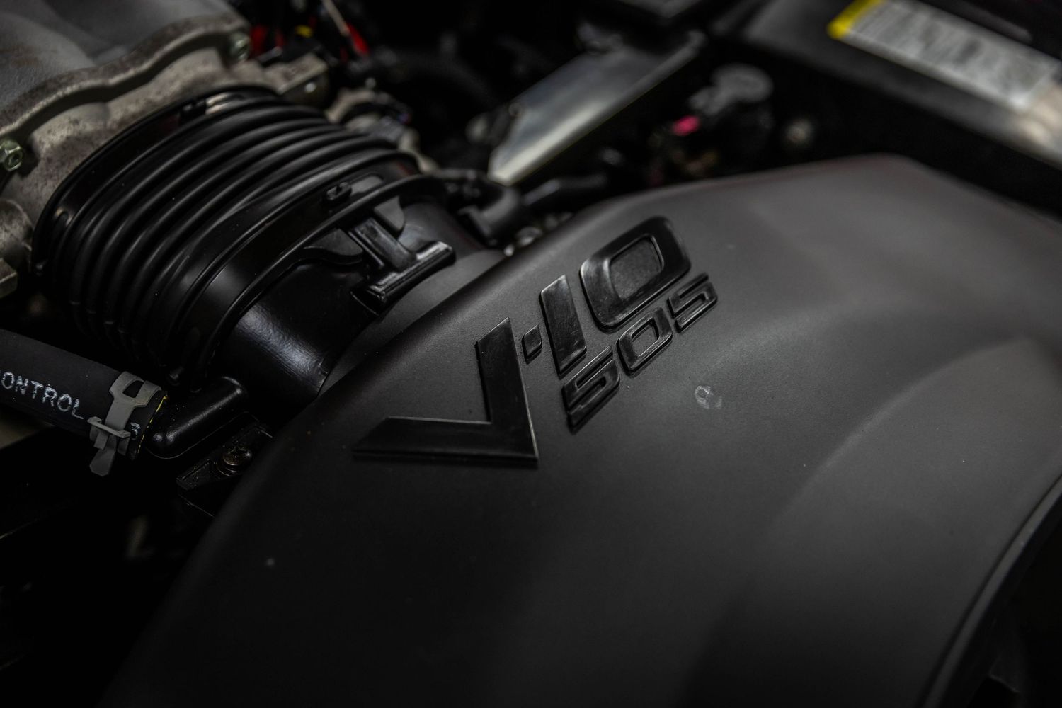 Close-up view of black matte car hood with aggressive vents and angular design details.