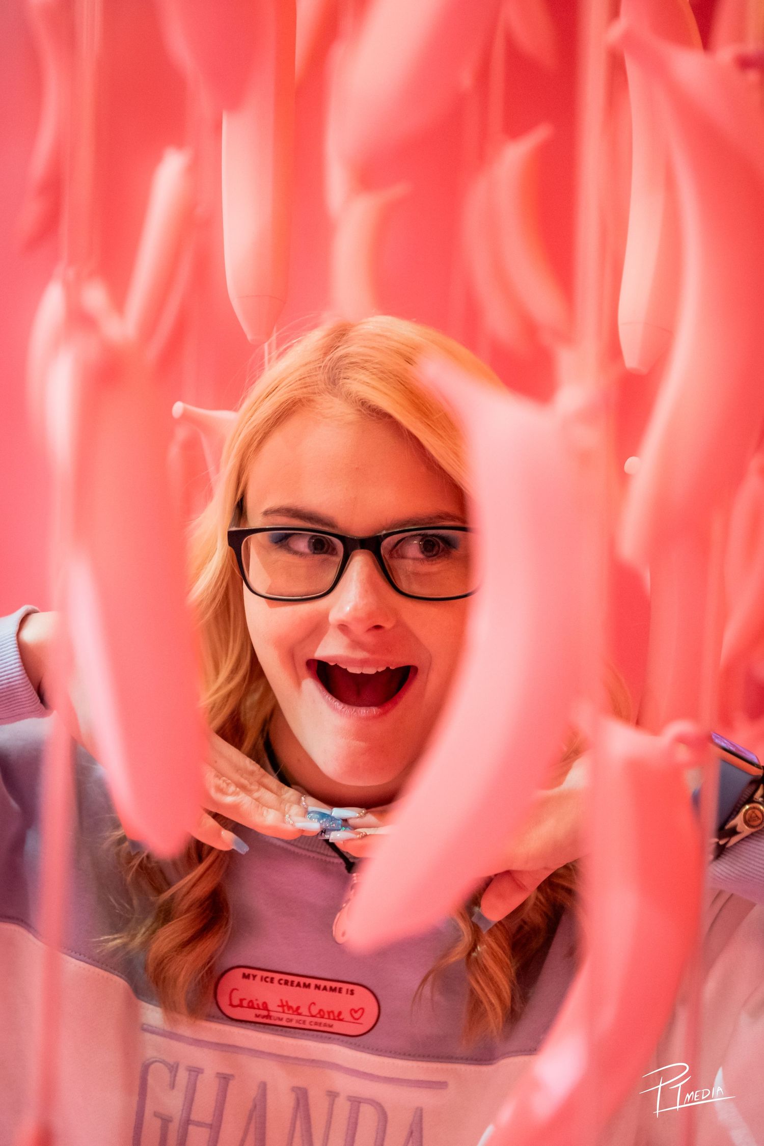 A series of five selfies with pink lighting showing playful expressions and glasses.