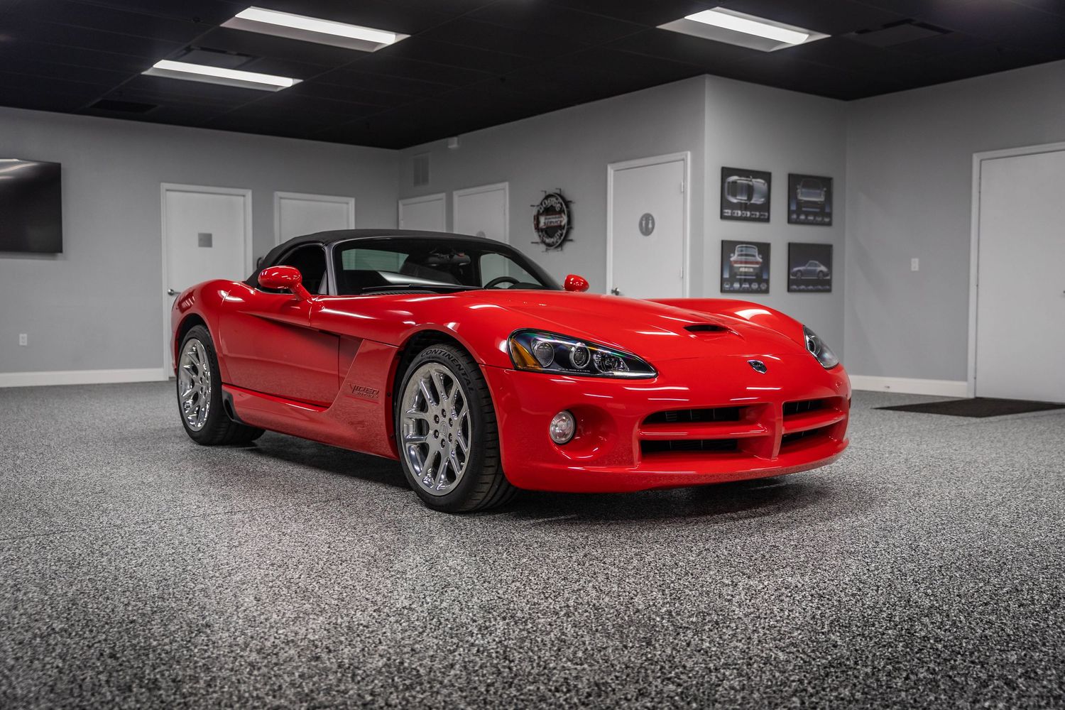 A sleek red Dodge Viper sports car shown in multiple angles inside a modern garage with polished concrete floors.