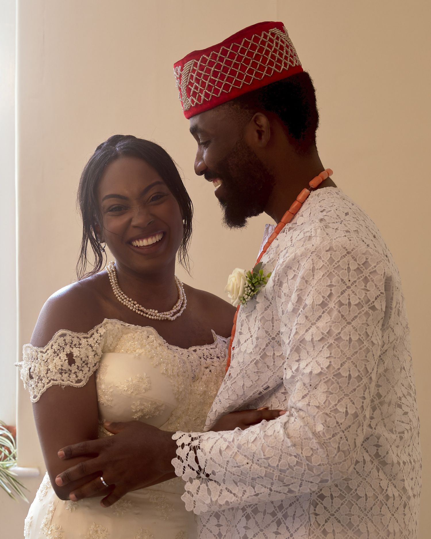 Newlywed couple smiling together during a relaxed moment indoors.