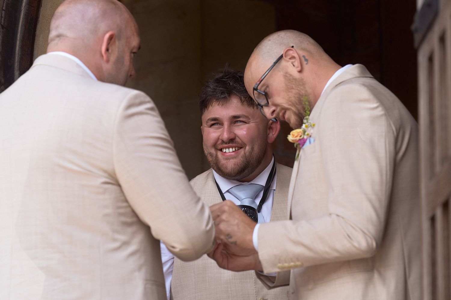 Groom laughing with two members of the wedding party before the ceremony.