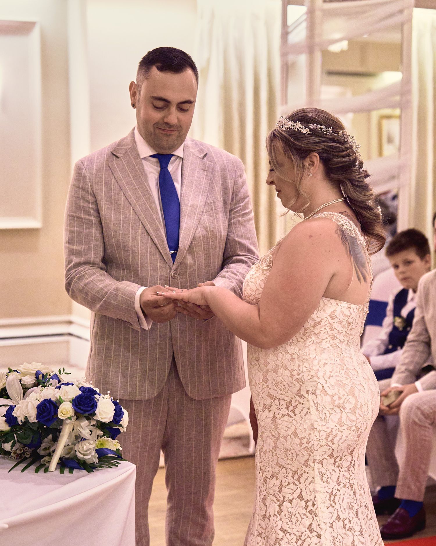 Bride and groom exchanging rings during an intimate indoor wedding ceremony.